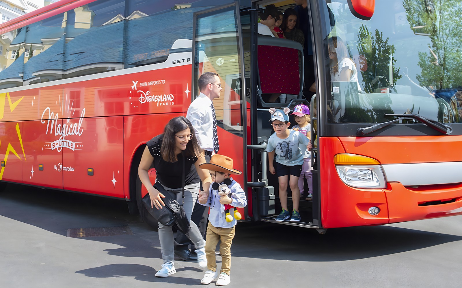 Les familles descendent du bus Magic Shuttle à l'entrée de Disneyland Paris.