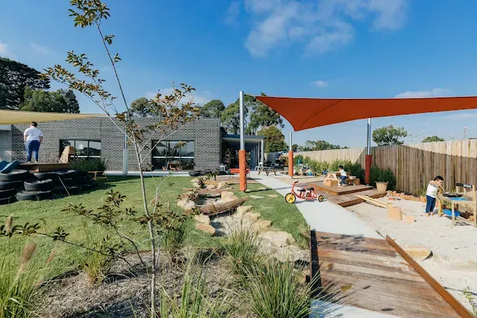 Luxurious modern interior with a sculptural art piece, floating books, a sleek marble bench, ambient lighting, and a gold metal partition
