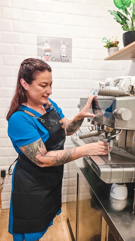 Barista preparing coffee with an espresso machine in a café
