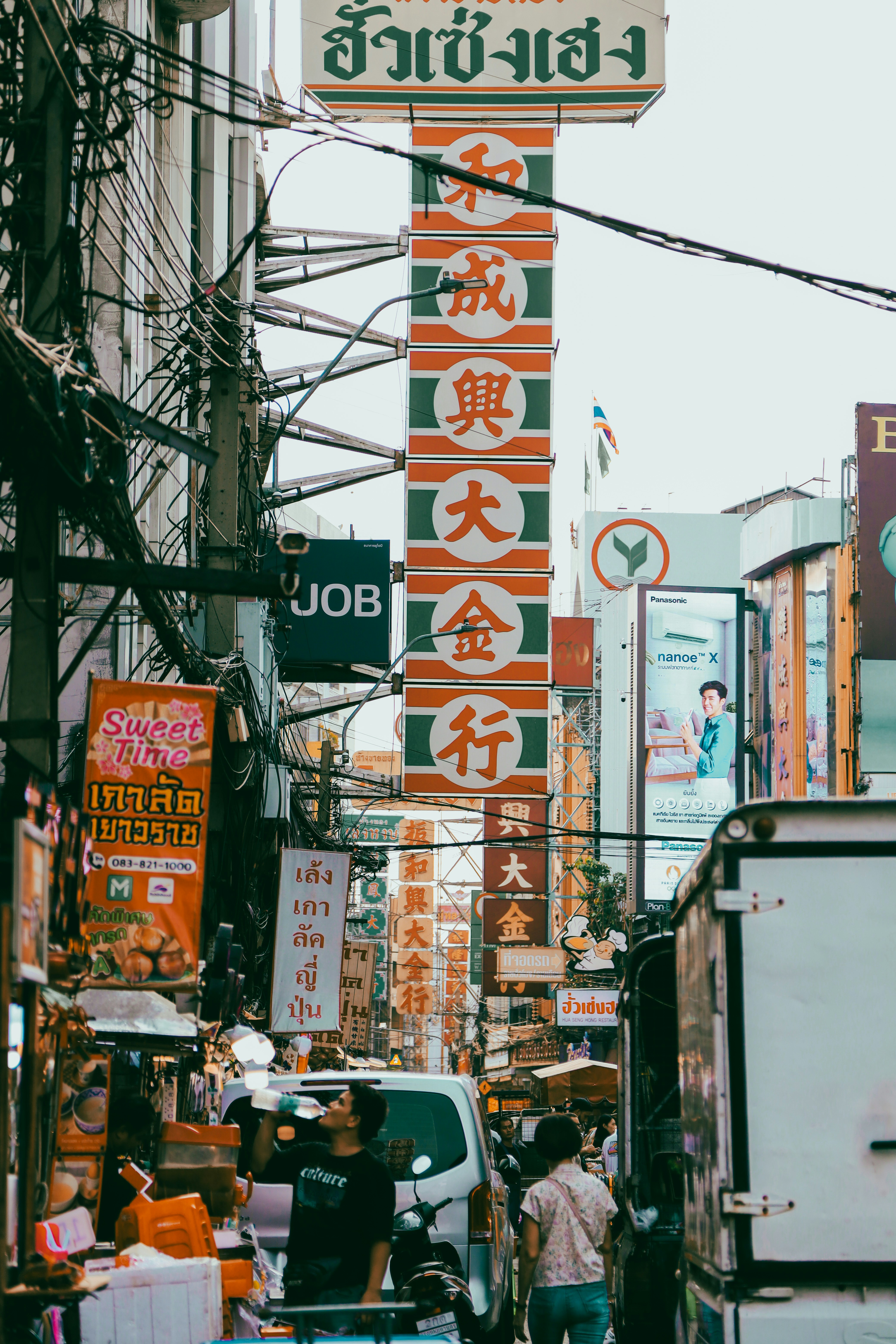 a busy asian street with many signs on it
