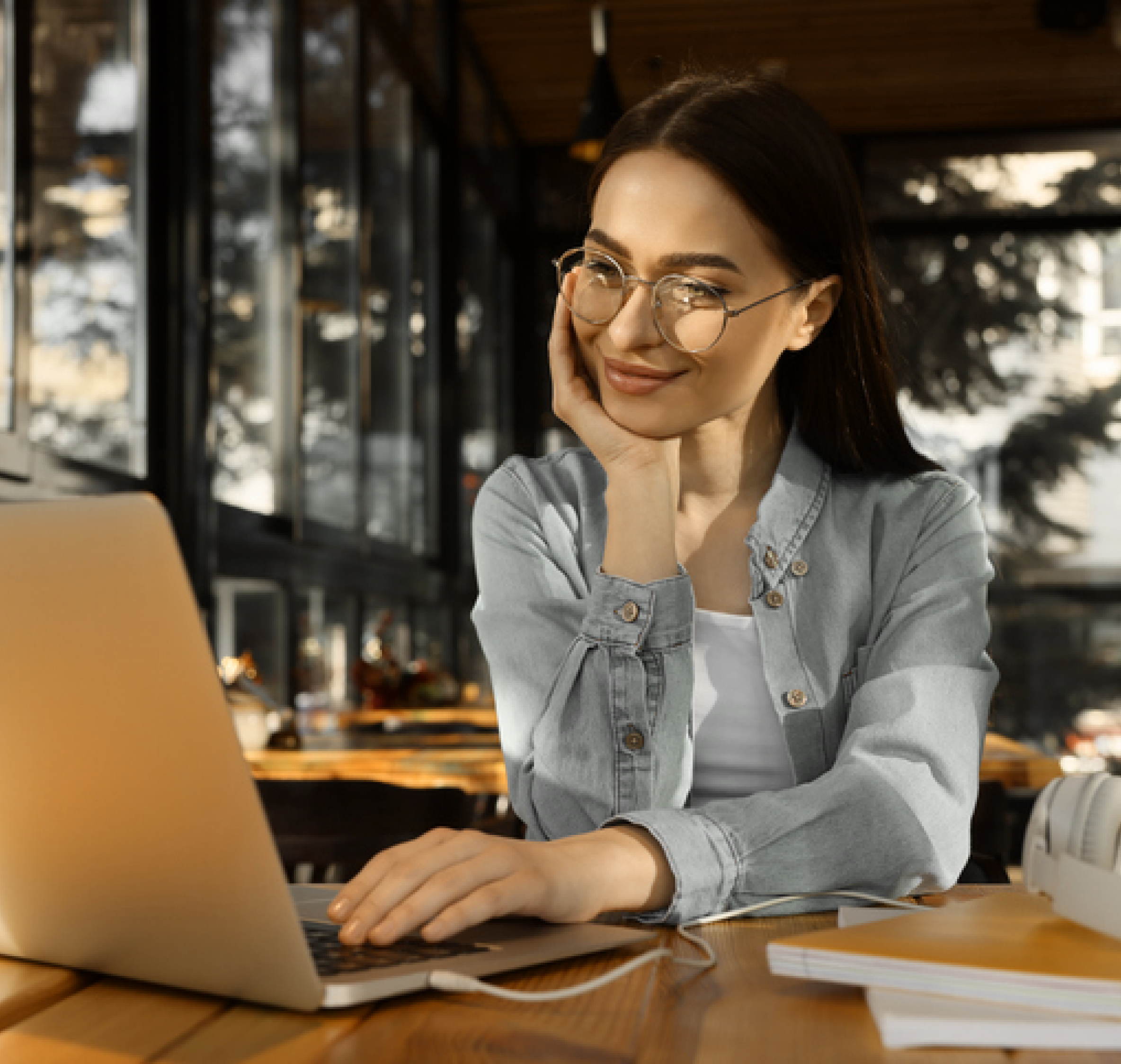 Mulher com a mão no rosto com um sorriso mexendo no computador