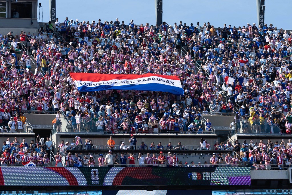 Paraguay fans wave a large República del Paraguay flag in the stands during the World Cup Round of 16 against France