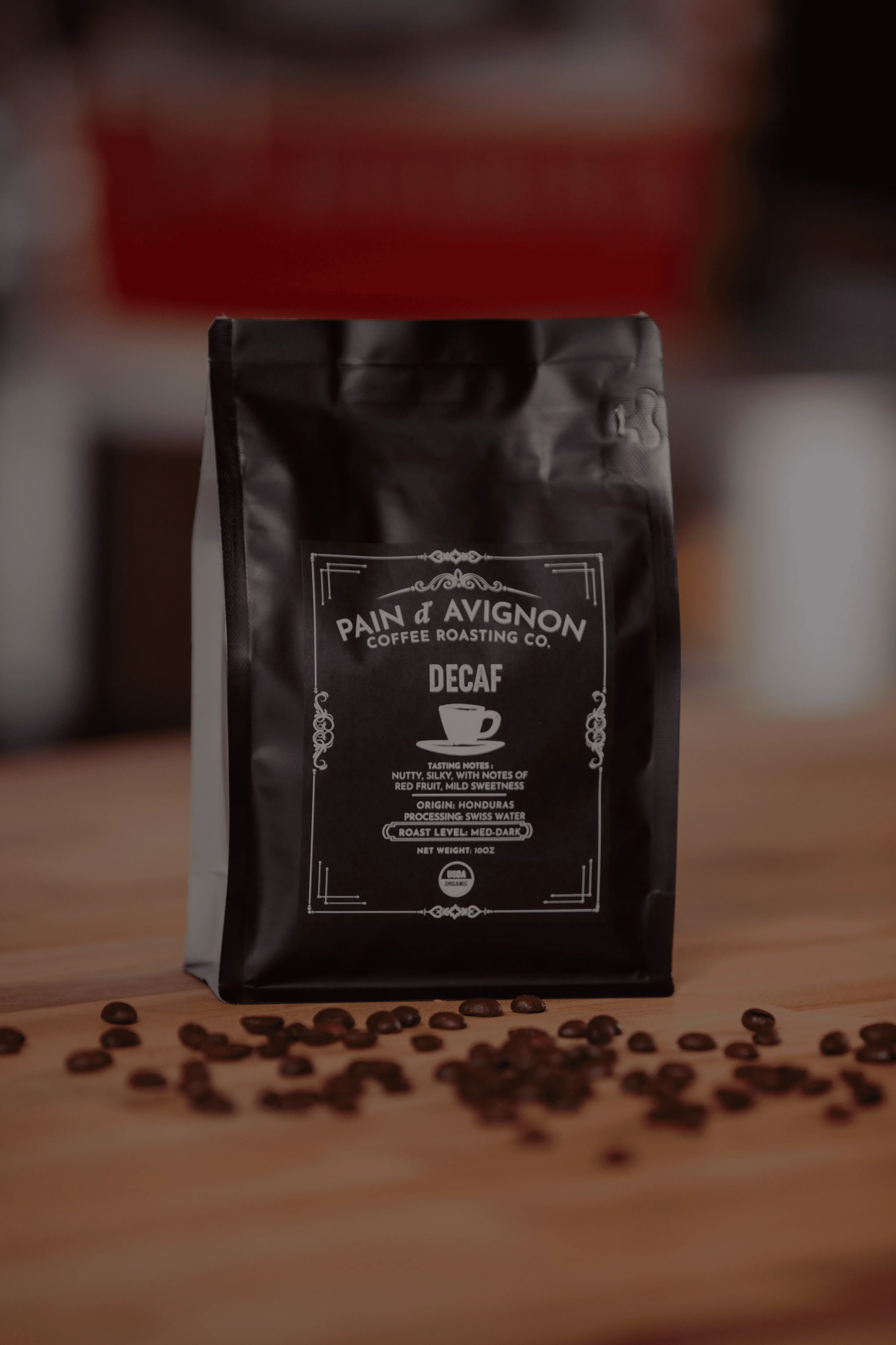 ain d'Avignon Coffee Roasting Co. Swiss Processed Decaf — dark bag with branded label, espresso roast with balanced dark chocolate notes