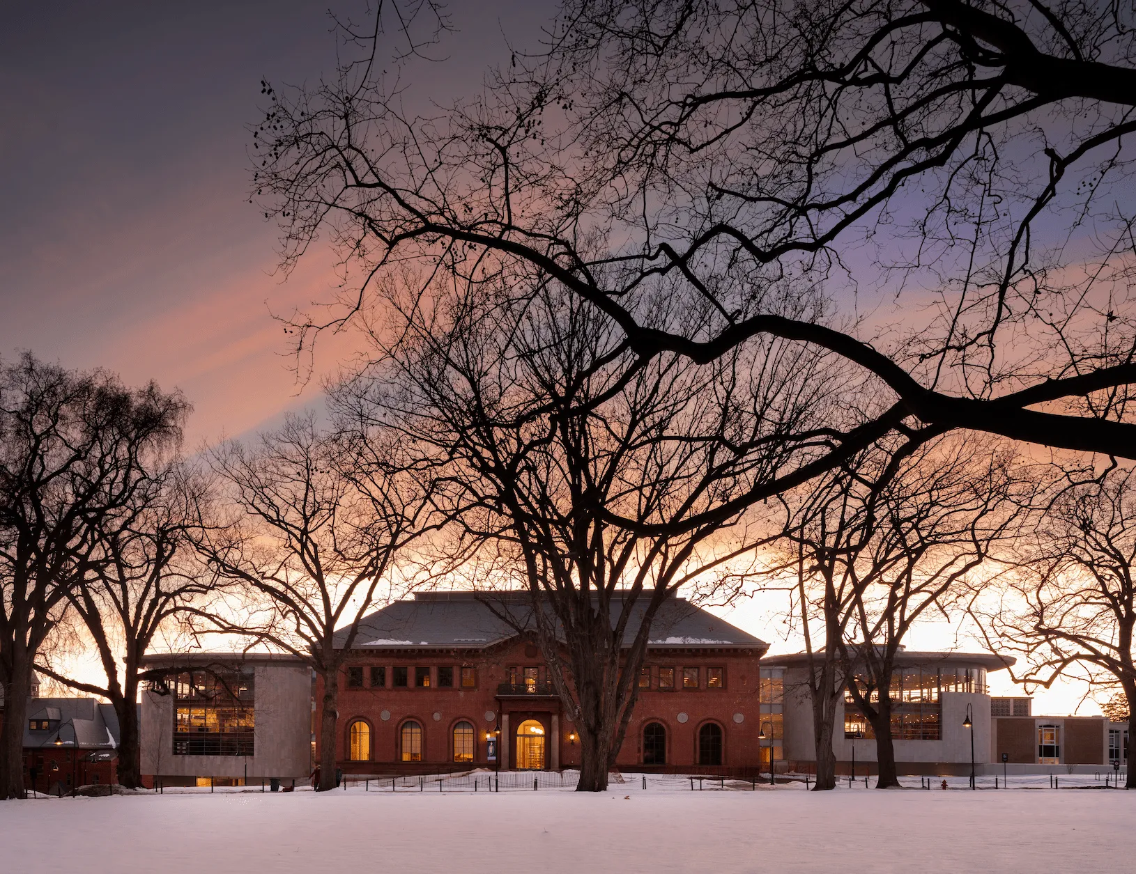 Sunset exterior facade with side pavilion internal illumination and soffit uplight at perimeter