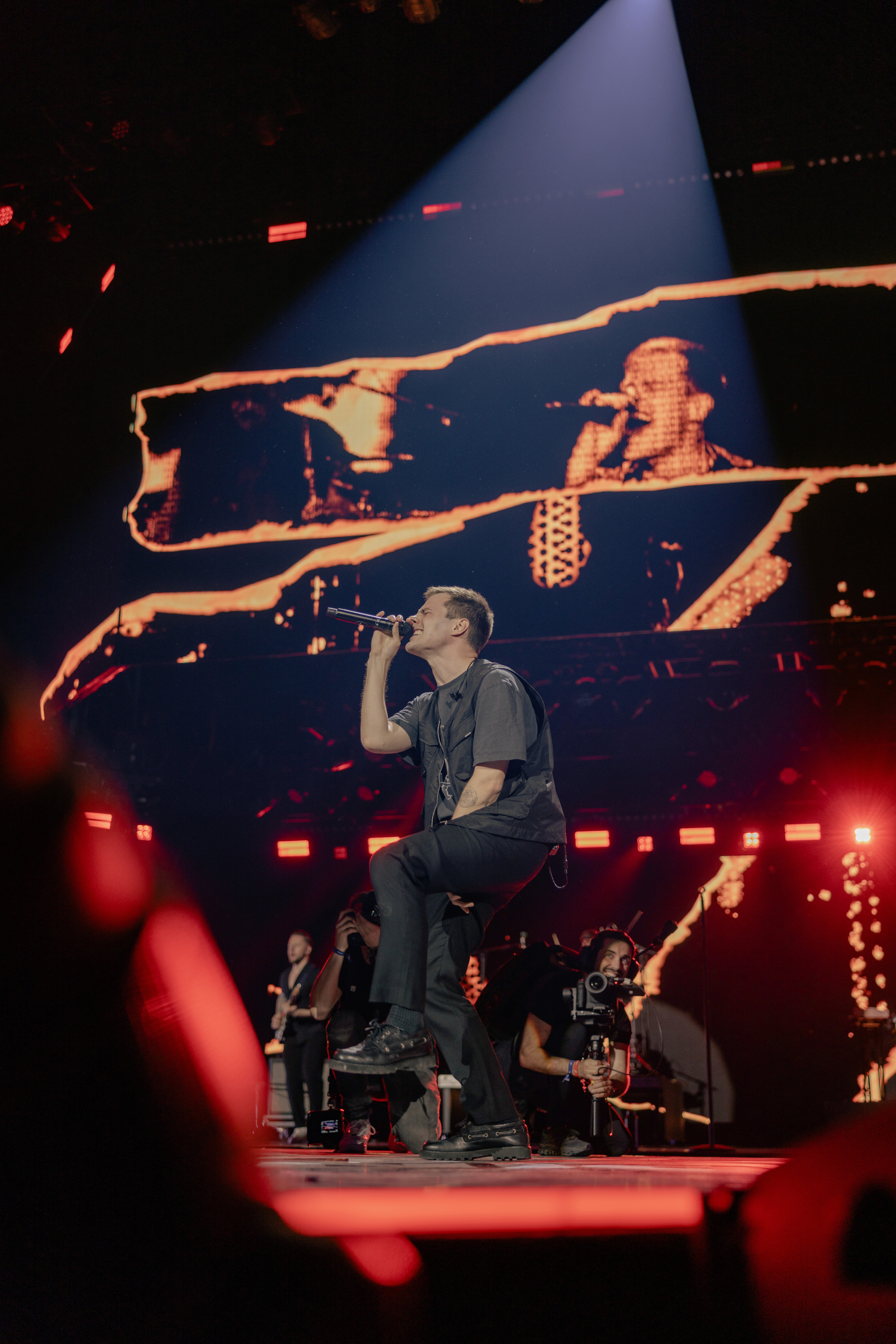 Flat lay of makeup essentials: brush, foundation, and powder on a beige background