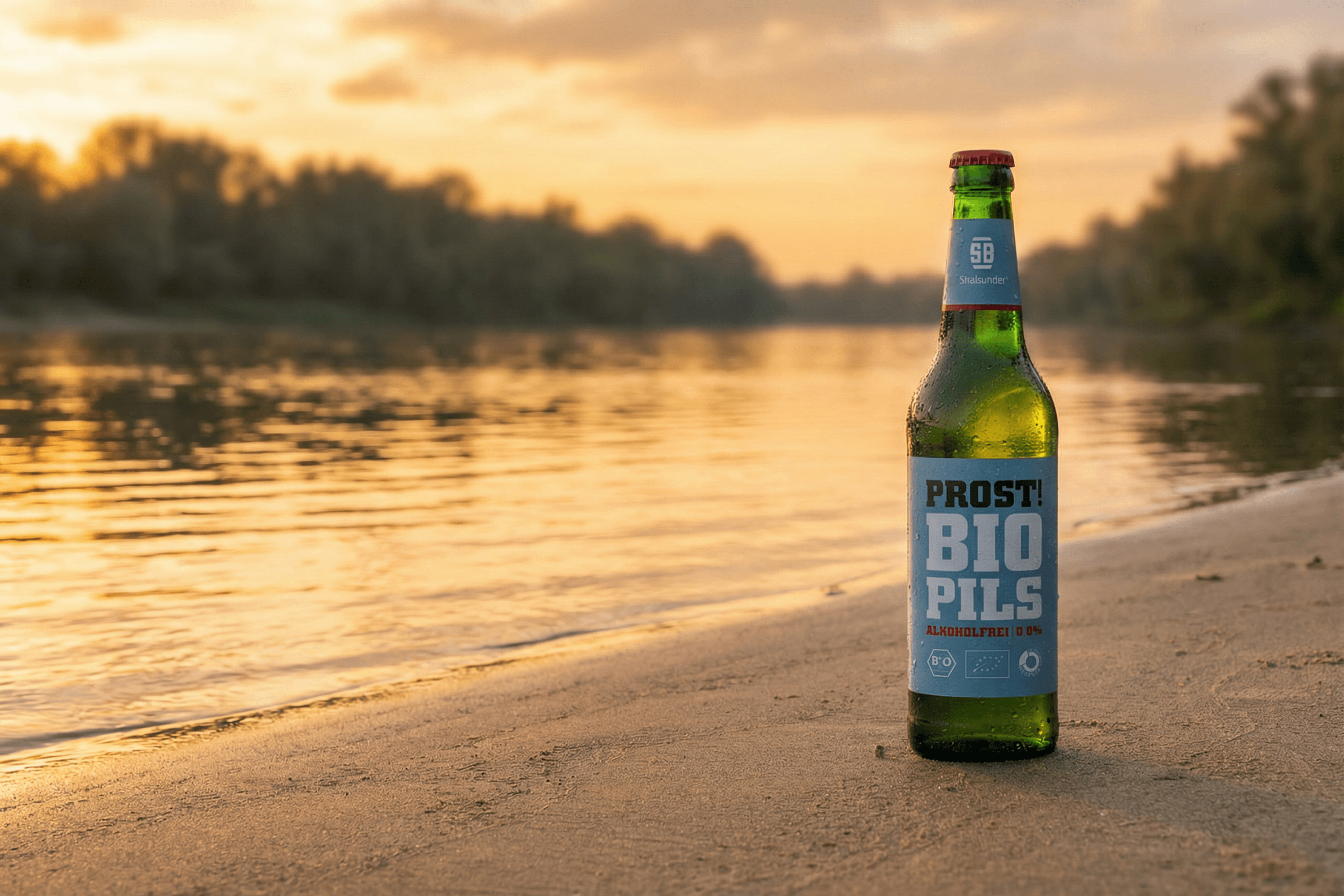 Bottle of Stralsunder Bio Pils on a sandy beach at sunset