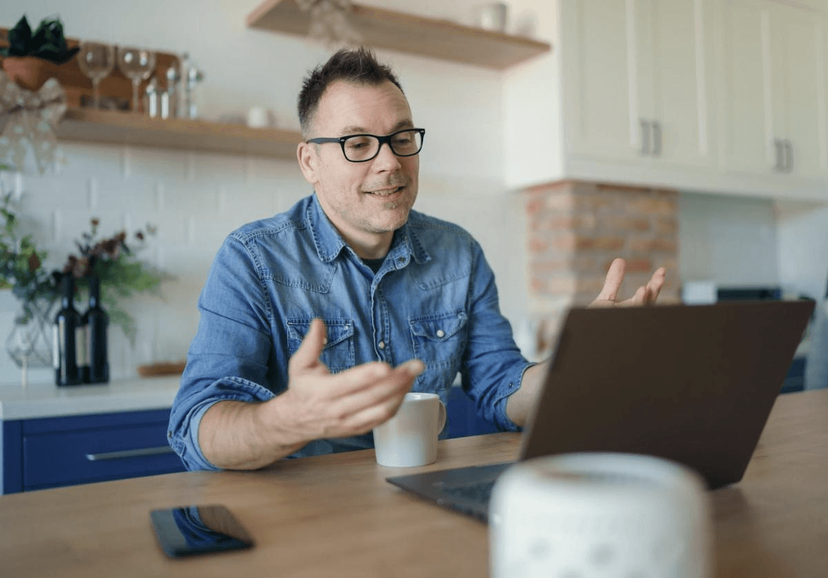 SaaS sales funnel: Smiling man talking in front of his laptop