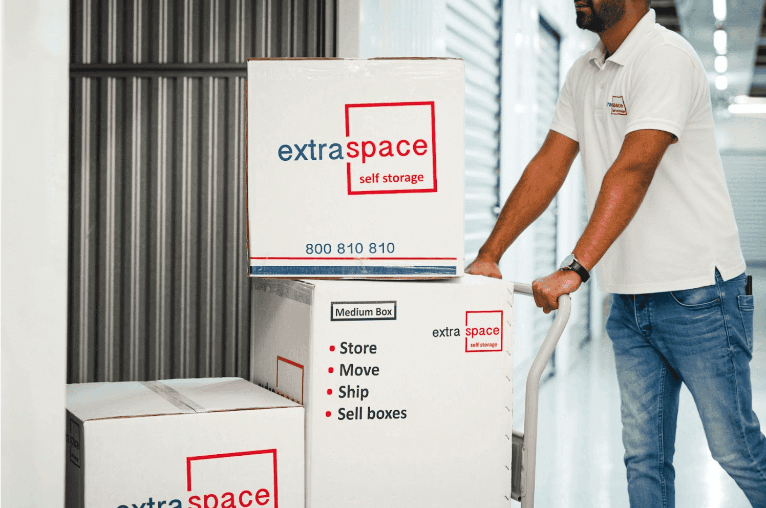 ExtraSpace business storage Dubai worker transporting service-labeled boxes.