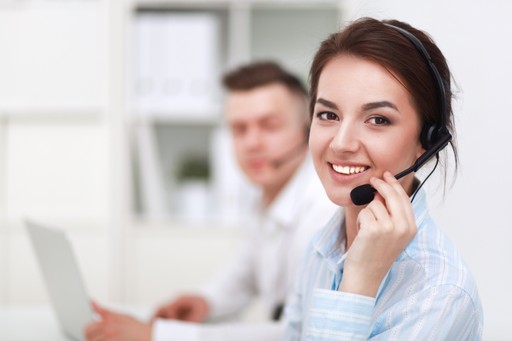 Egészségügyi dolgozó maszkban és kesztyűben dolgozik egy számítógépnél laboratóriumi környezetben.