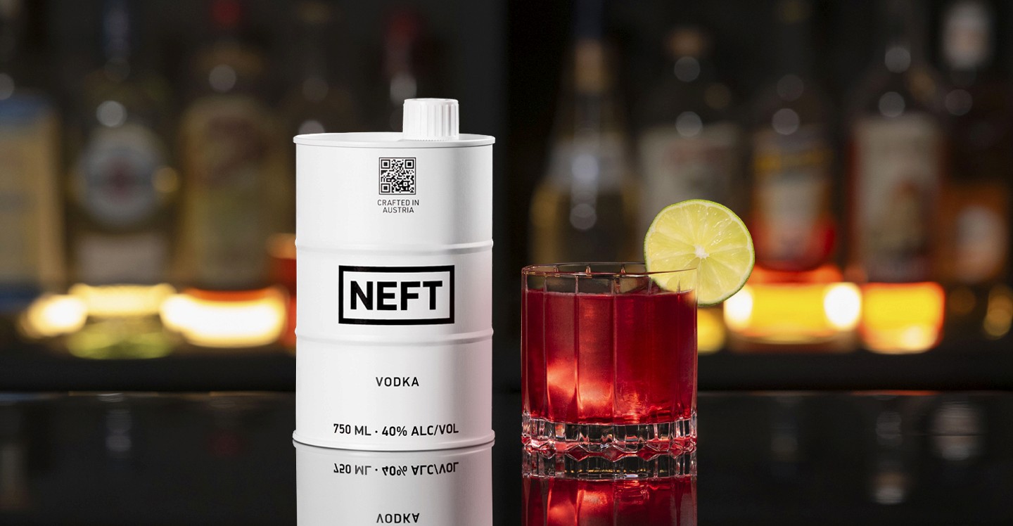 A NEFT Barrel and a glass of Vodka Cranberry on a bar counter.