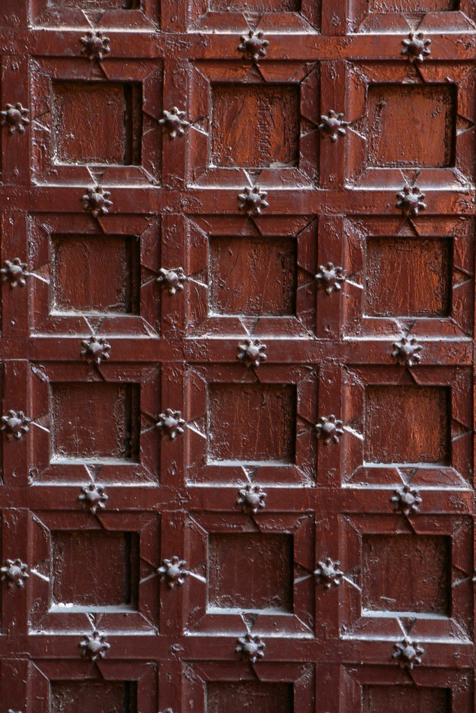 A close up of a wooden door with a clock on it