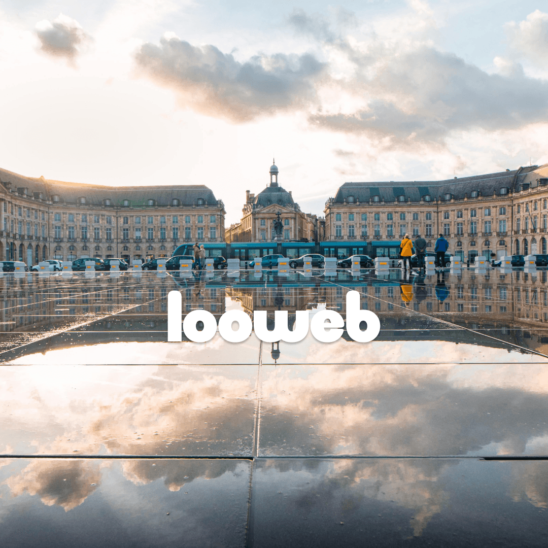 Two professionals collaborate at a desk, discussing a project displayed on a computer screen in a modern office setting.