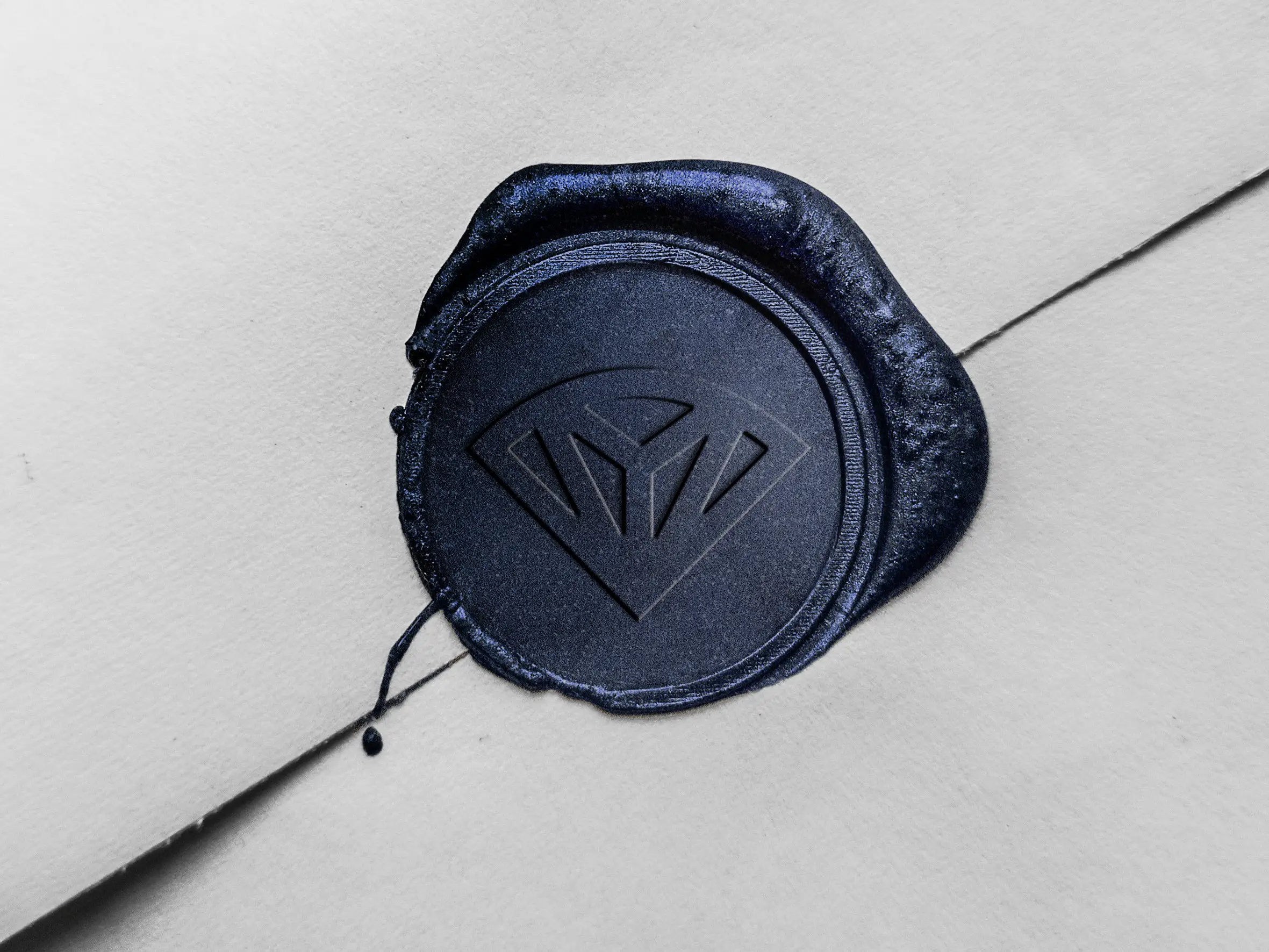 Navy wax seal stamped with the Lazuli emblem on a white envelope