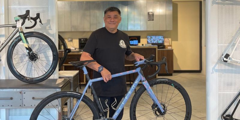 Owner of The Bike Artisans holding a custom bike. 