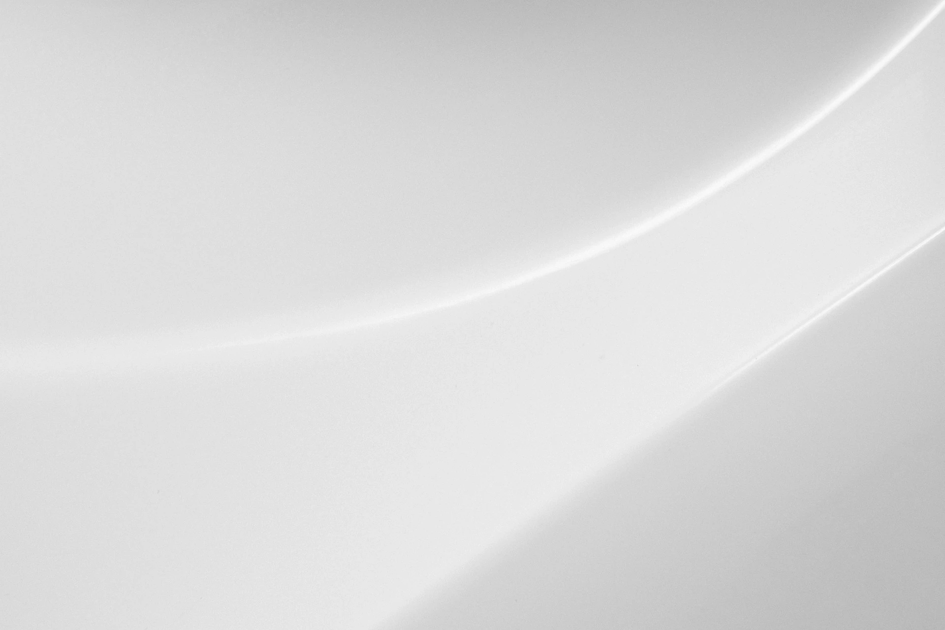 A smooth white surface with a soft curved shadow