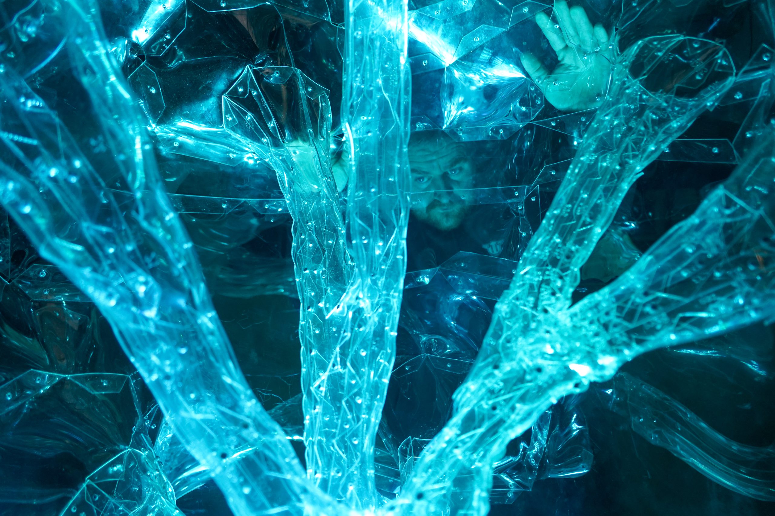 Woman wears a blue coat in a blue environment.