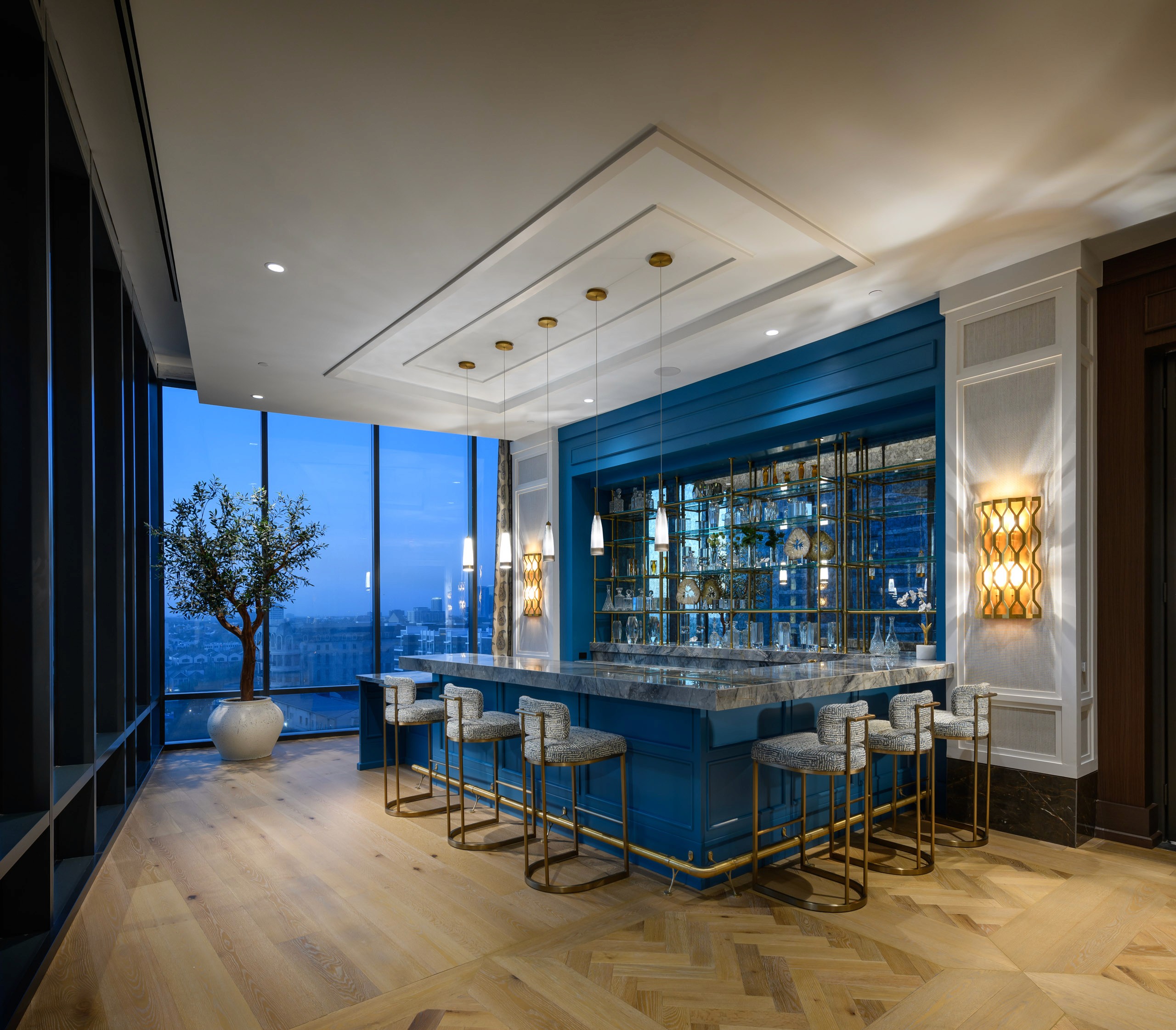 Modern bar with blue cabinets and marble countertop.