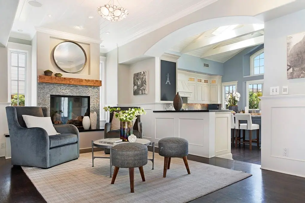 'Port Streets Remodel' space with fireplace, seating, and kitchen bar in natural light.