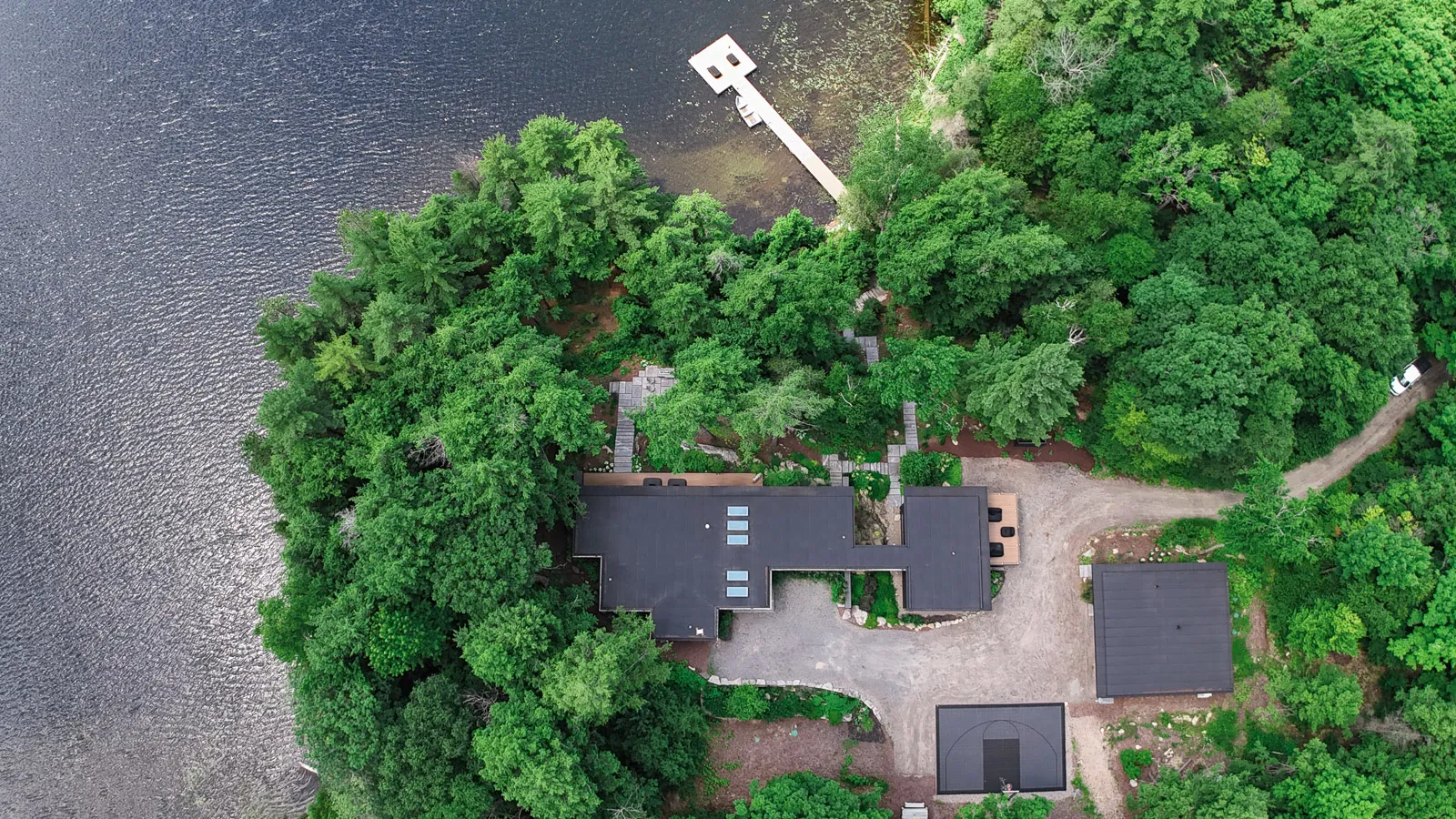 Private luxury cottage property with dock and sport court and granite landscaping.