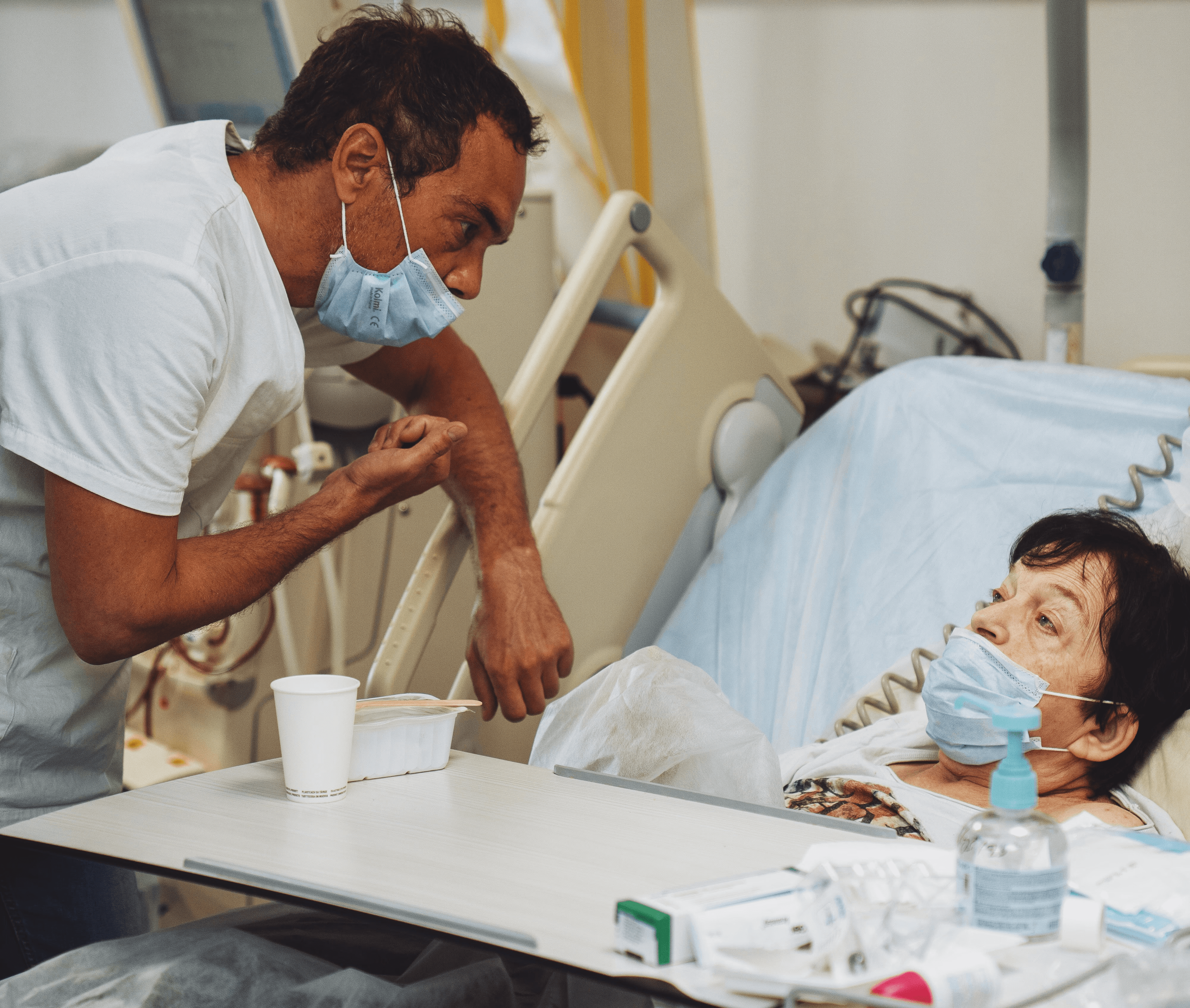 Patiente en séance de dialyse allongée, accompagnée par un kinésithérapeute