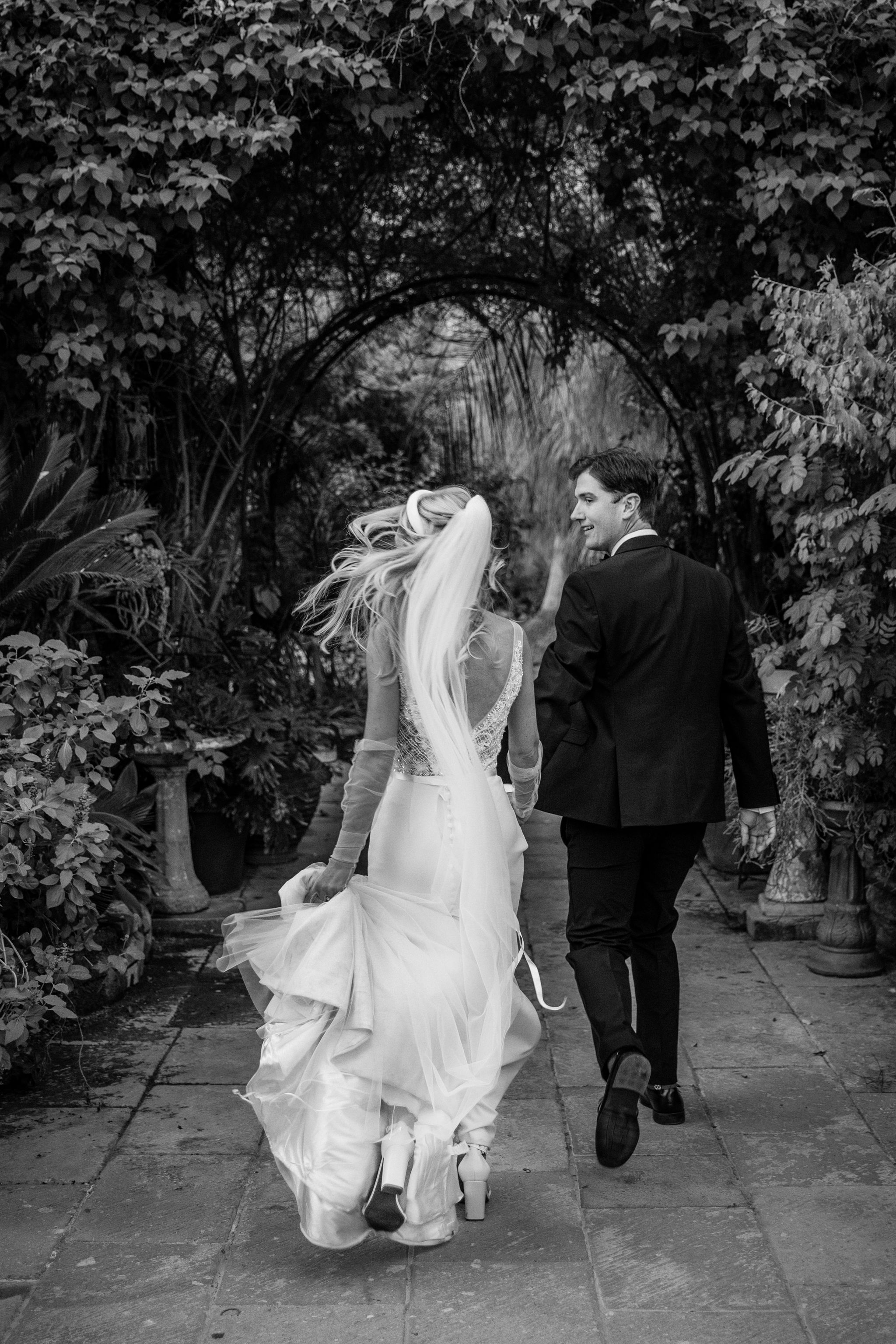 Bride in white dress walking on street, blurred motorcycle passing