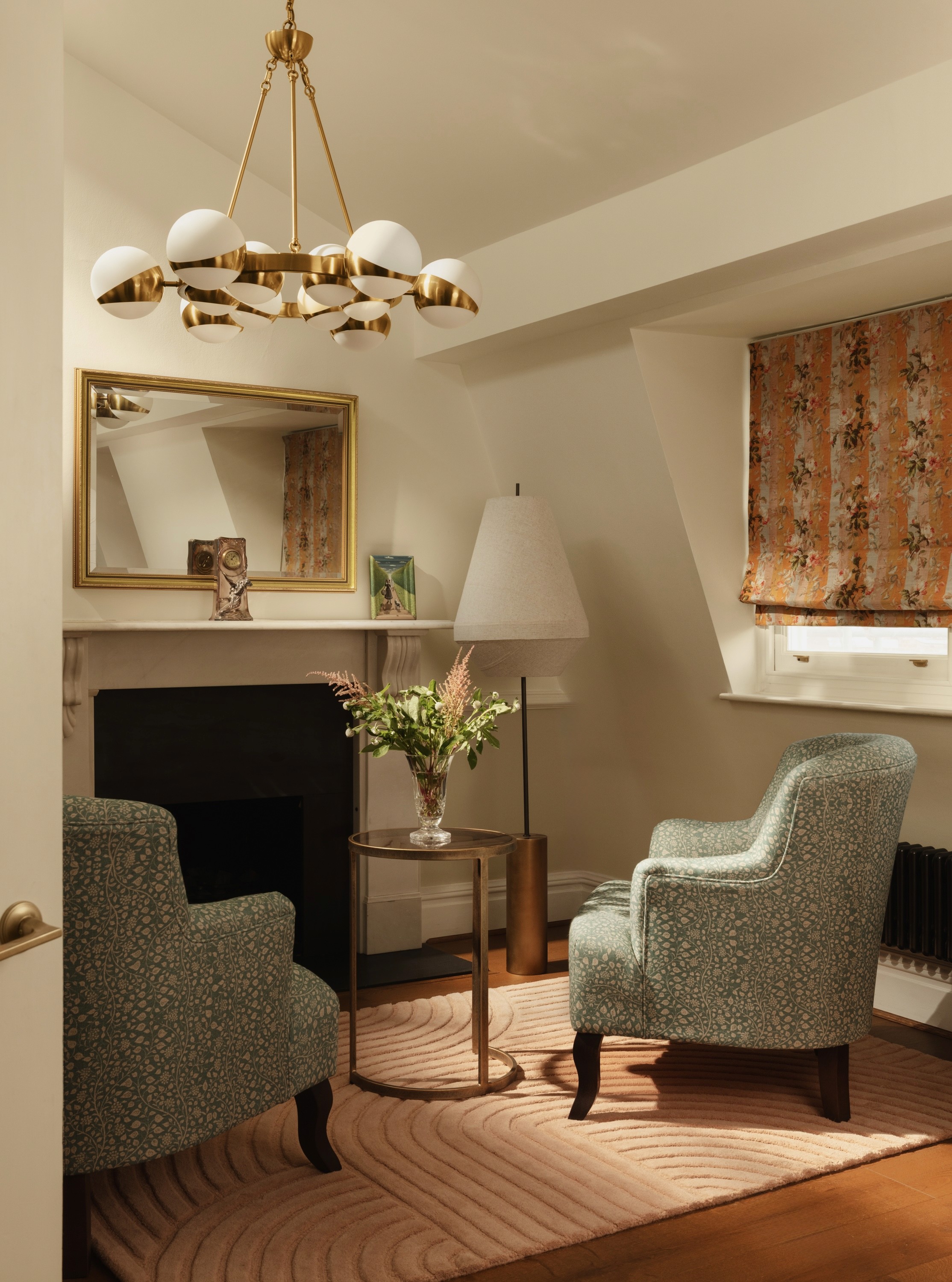 A softly lit hallway with a series of arched doorways, warm-toned walls, and wood flooring leading toward a seating area with neutral furniture.