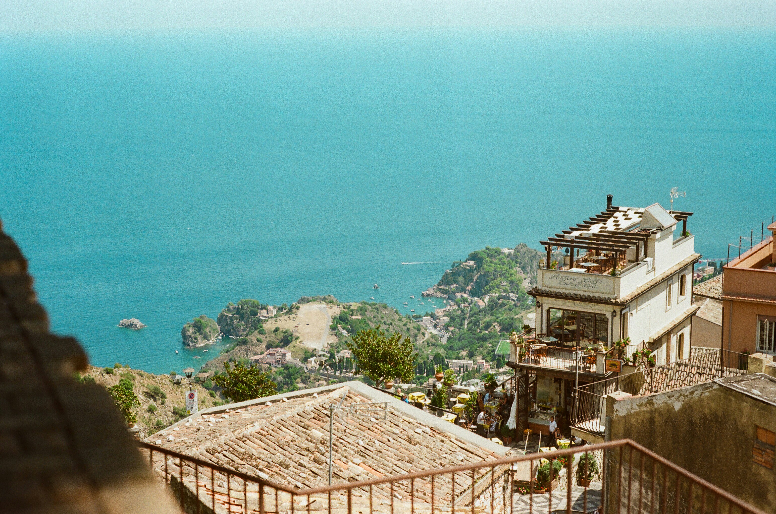 Coastal town with buildings overlooking the turquoise sea.
