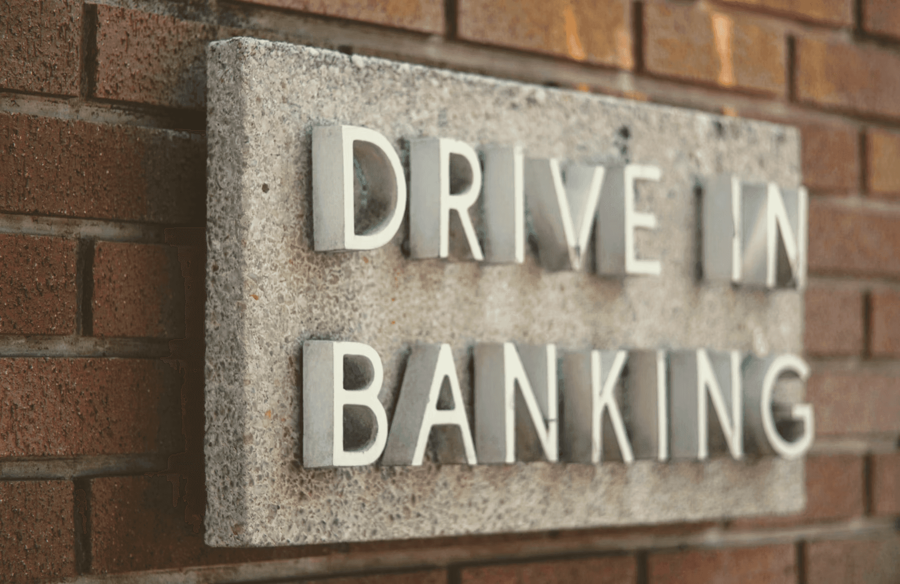 Drive-in banking sign on a brick wall, related to US bank accounts for non-residents