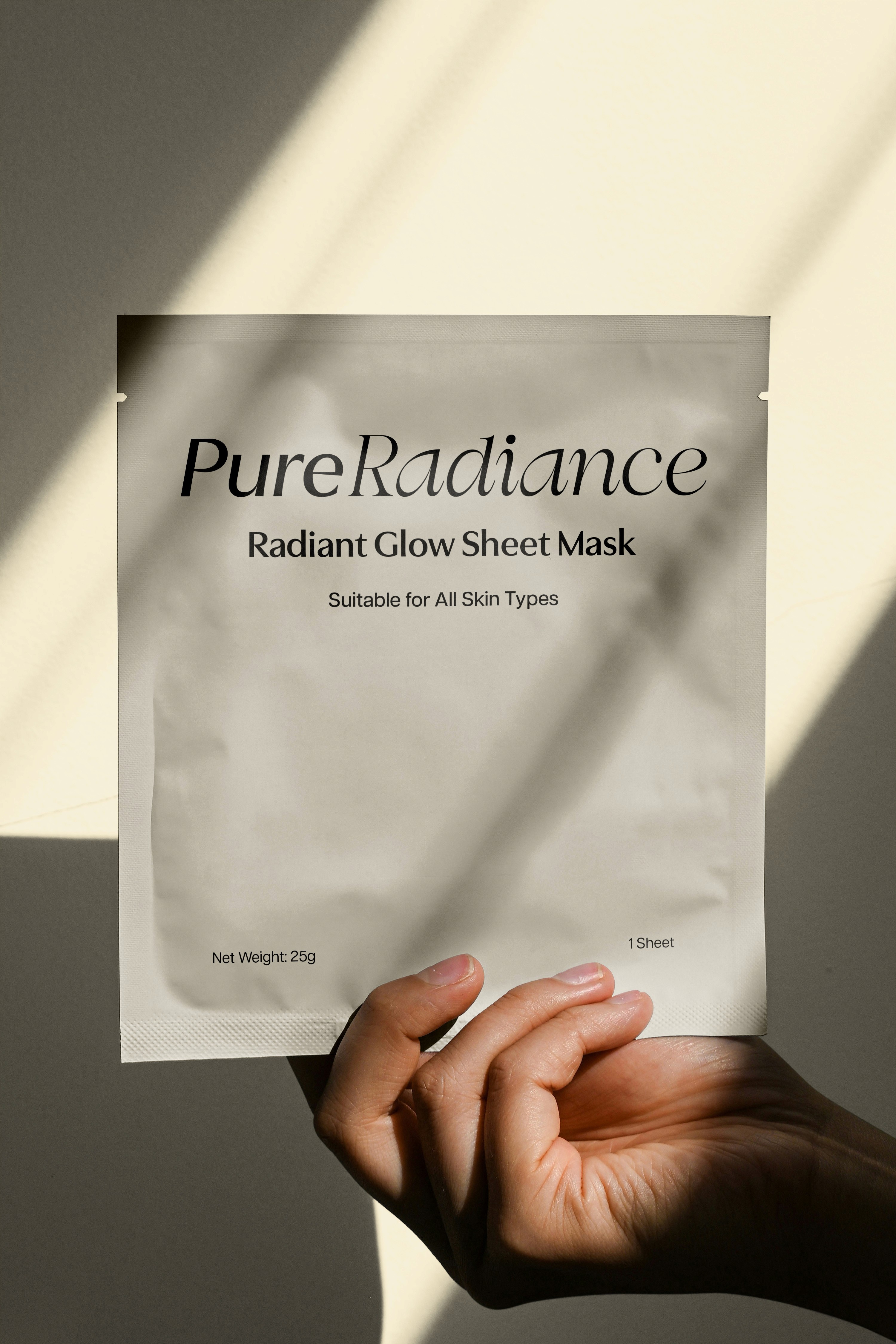 A hand holding a document with text, overlaid by soft shadows in a neutral background.