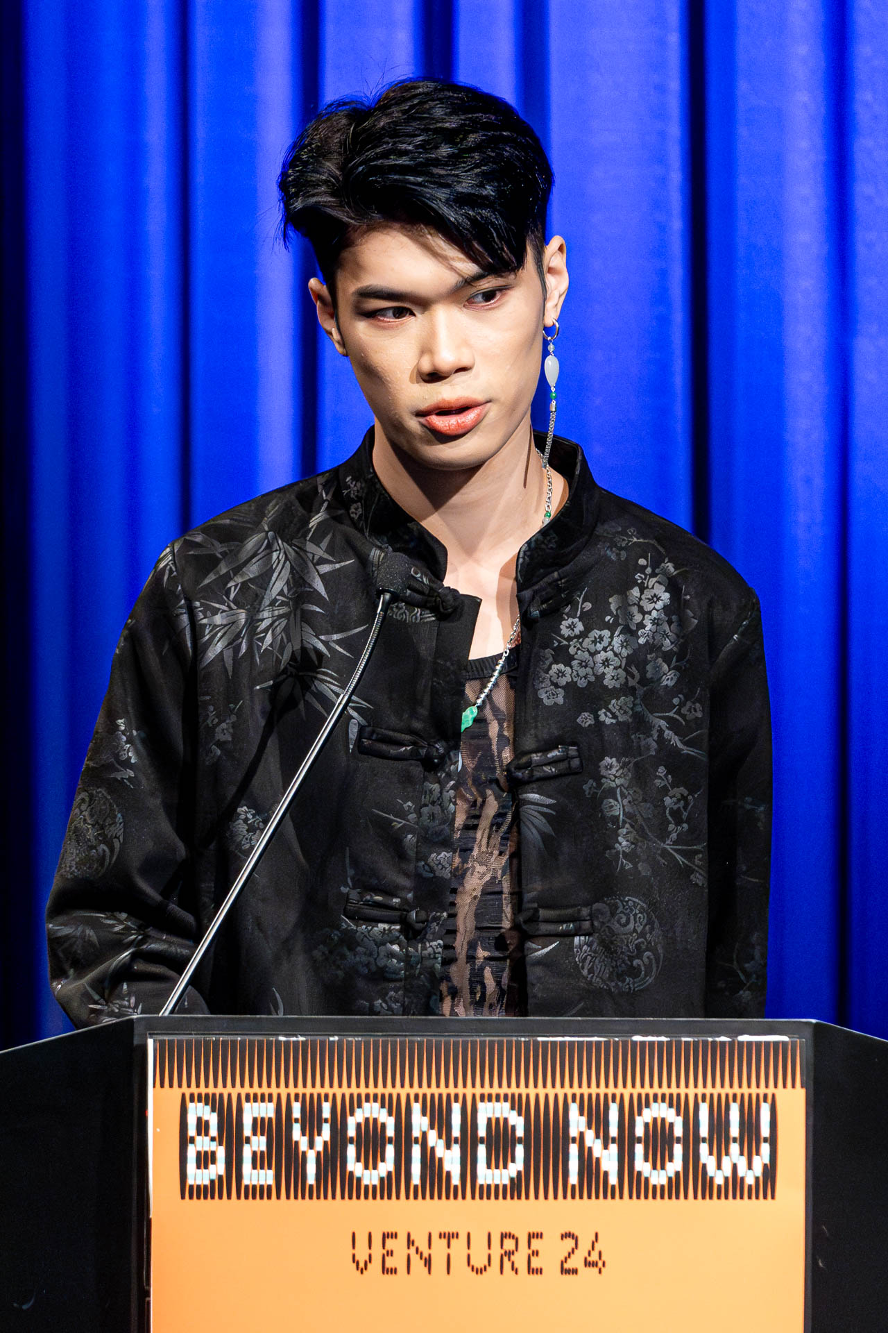 a student at a podium presenting a project in a Theatre