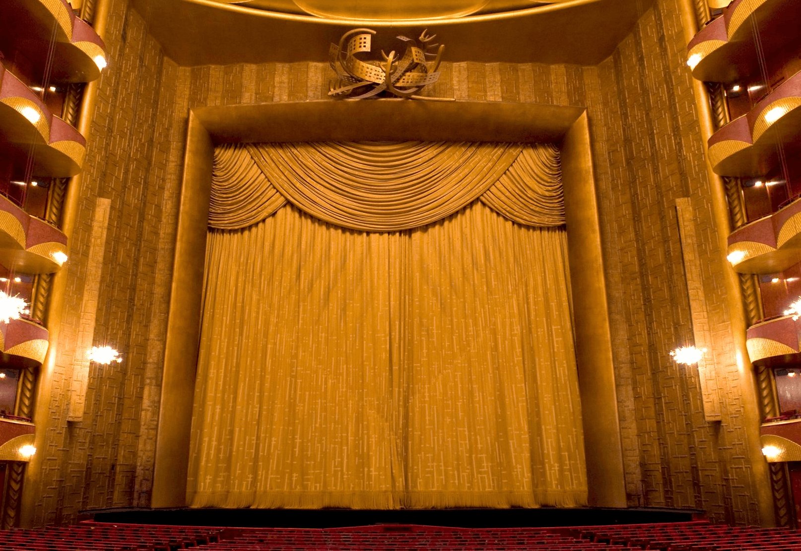 A view of a golden opera curtain inside the auditorium of an opera house.