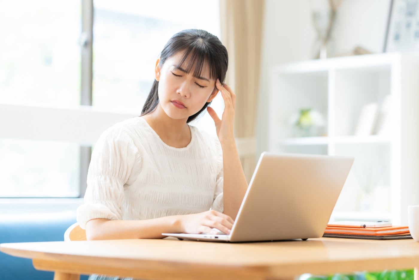 頭痛で顔をしかめる若い女性