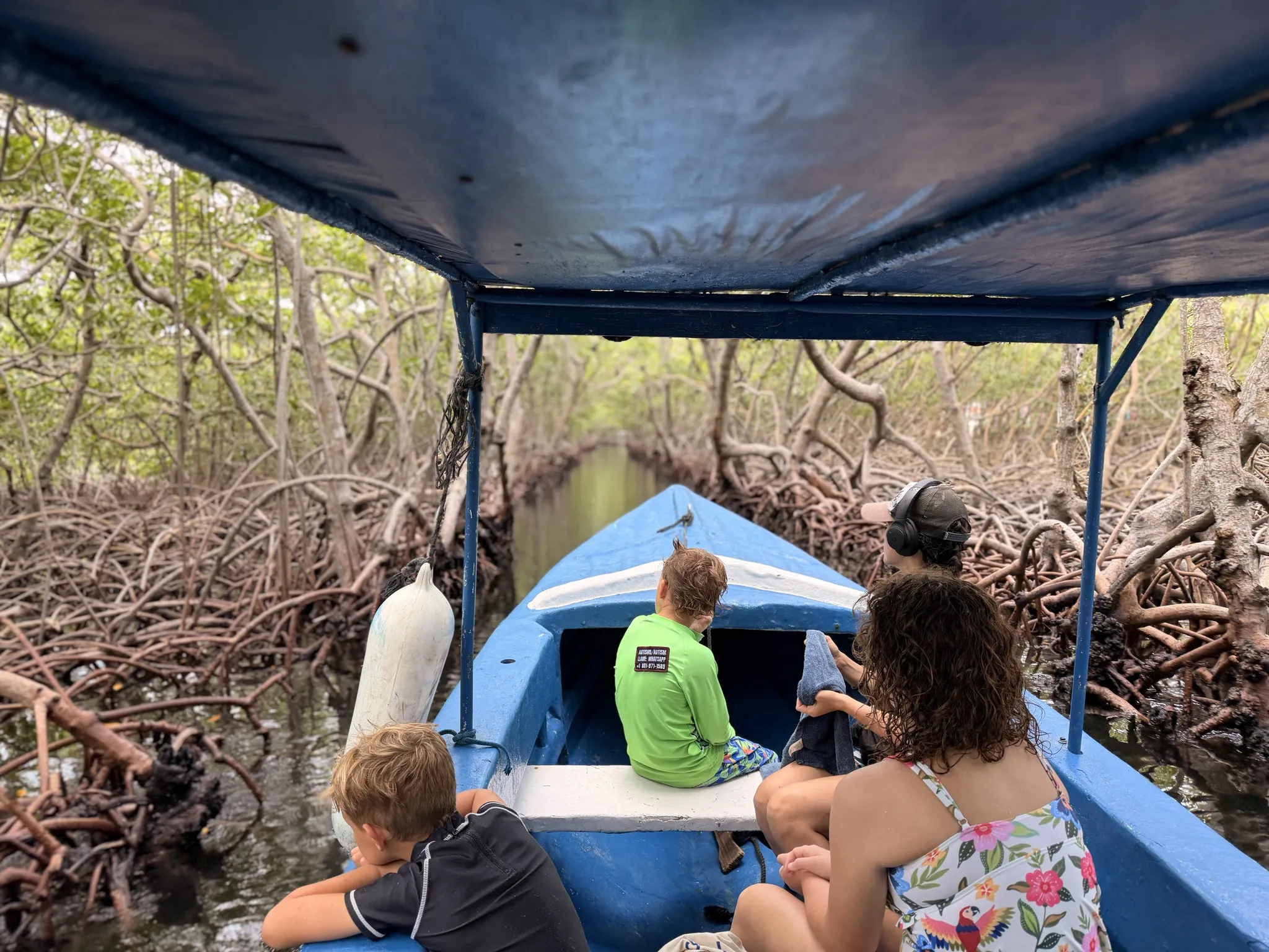 A family riding through the mangrove channels in an open boat near Oak Ridge, Roatán