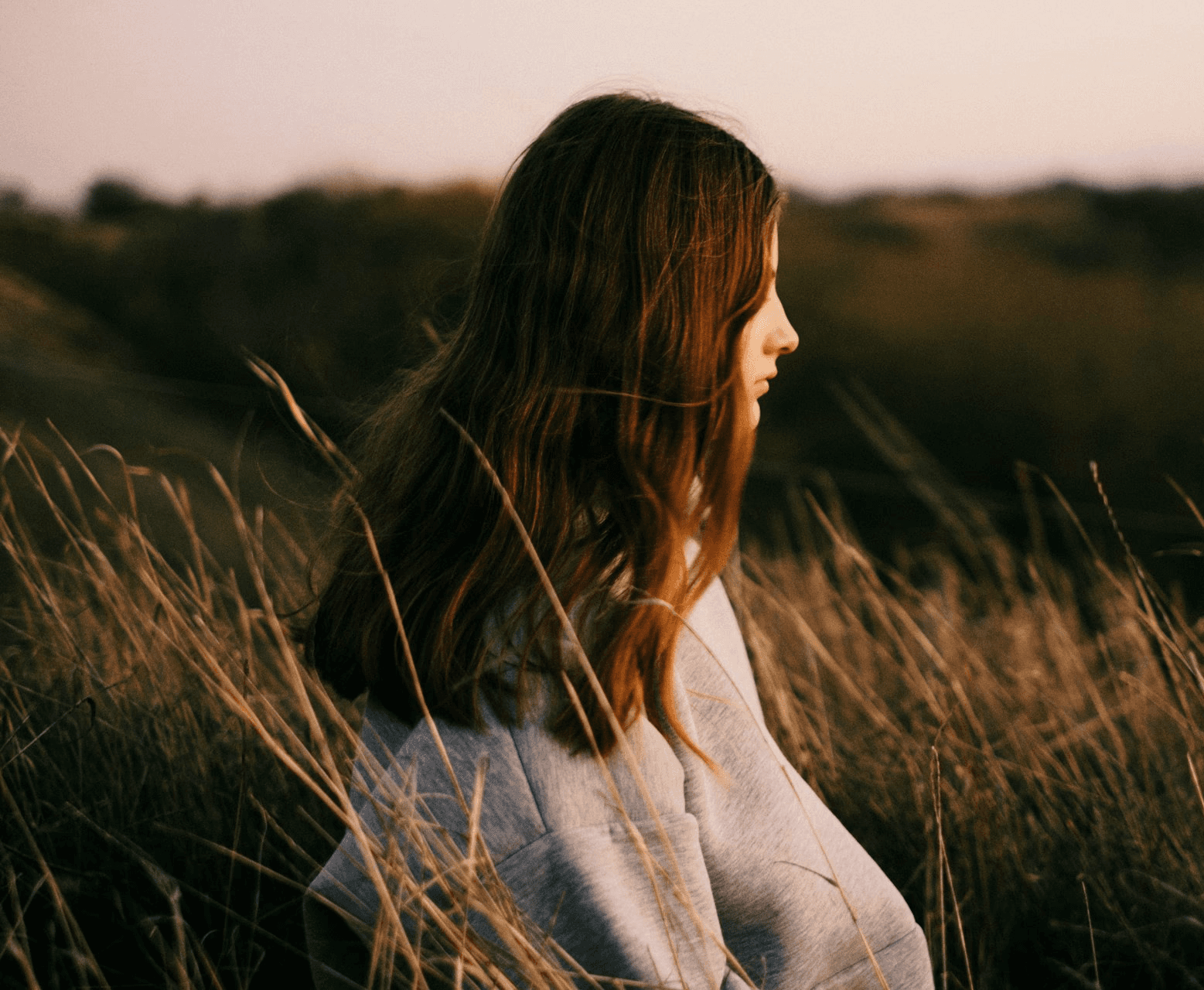 Woman strolling through open grass fields, enjoying nature