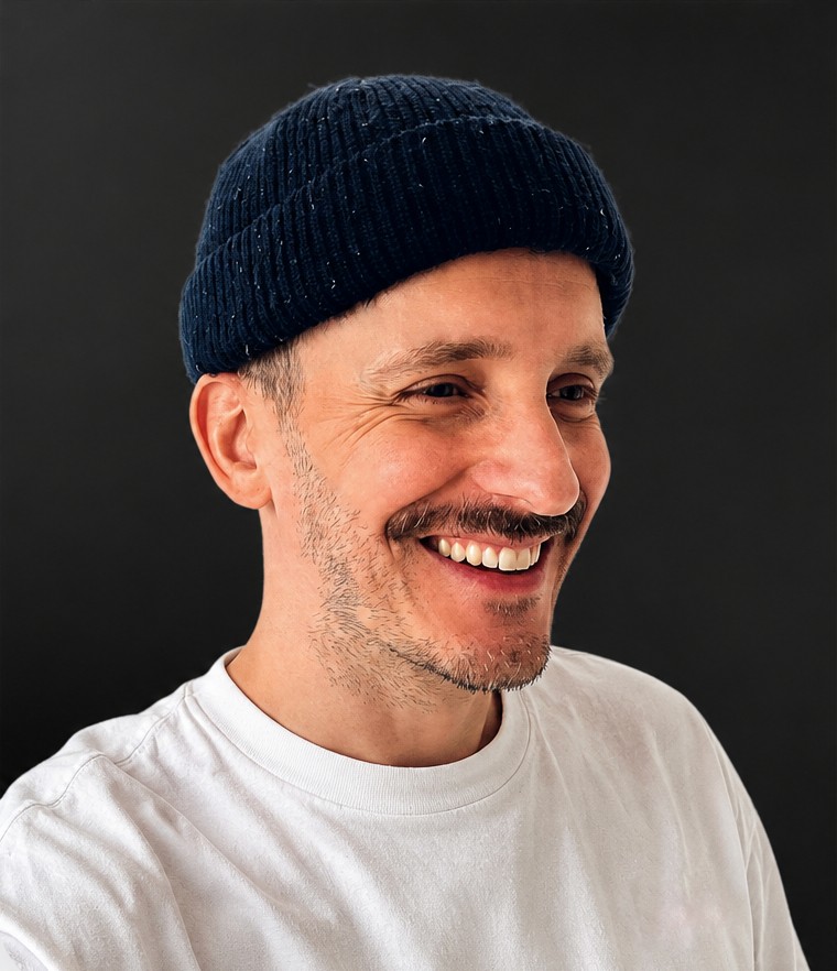 Rik, web and brand designer, smiling against a dark background