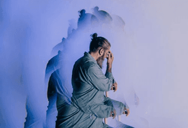 Multiple-exposure photo of a man holding his head, suggesting confusion and cognitive decline