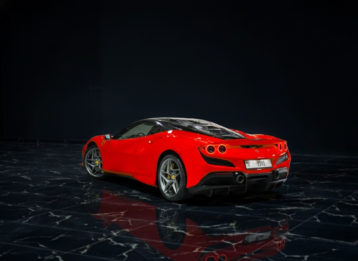 Ferrari F8 Tributo rear side view in red, showcasing aggressive coupe styling, sculpted aerodynamics, and iconic Ferrari performance.