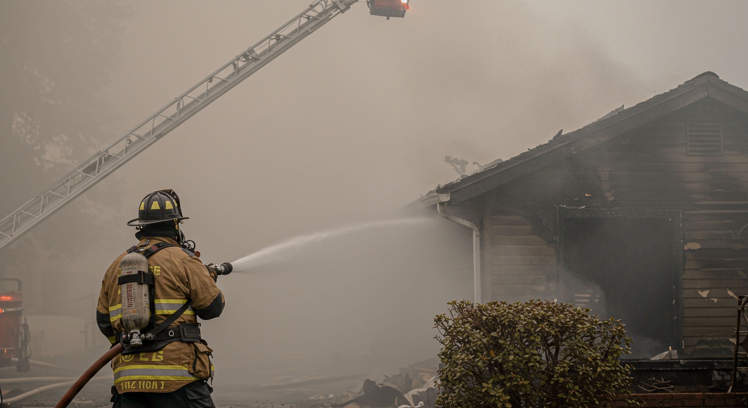 A firfighter hoses done a burnt house.