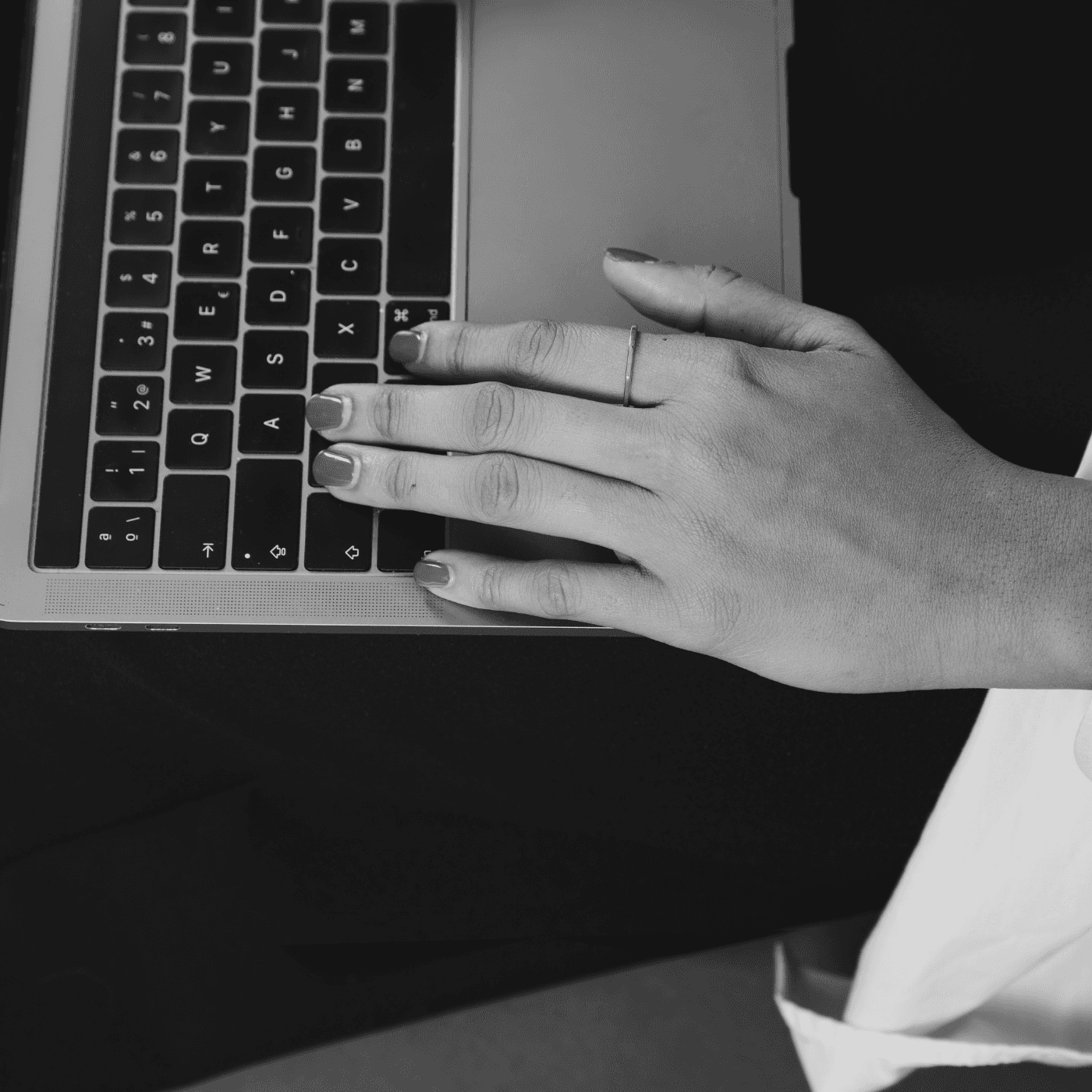 Una mano de una mujer sobre un teclado de ordenador portatil.