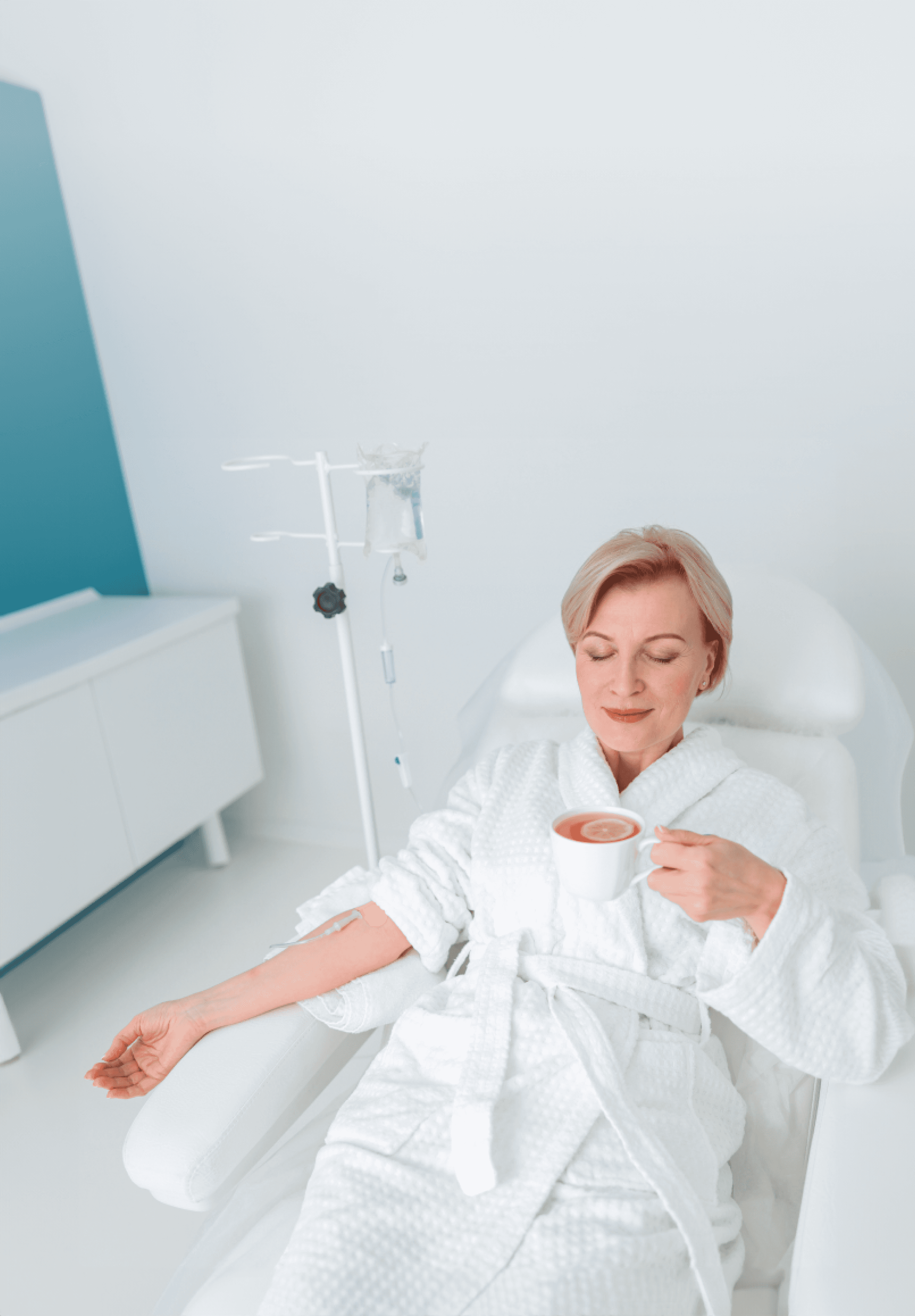 Older woman on IV drip drinking orange juice