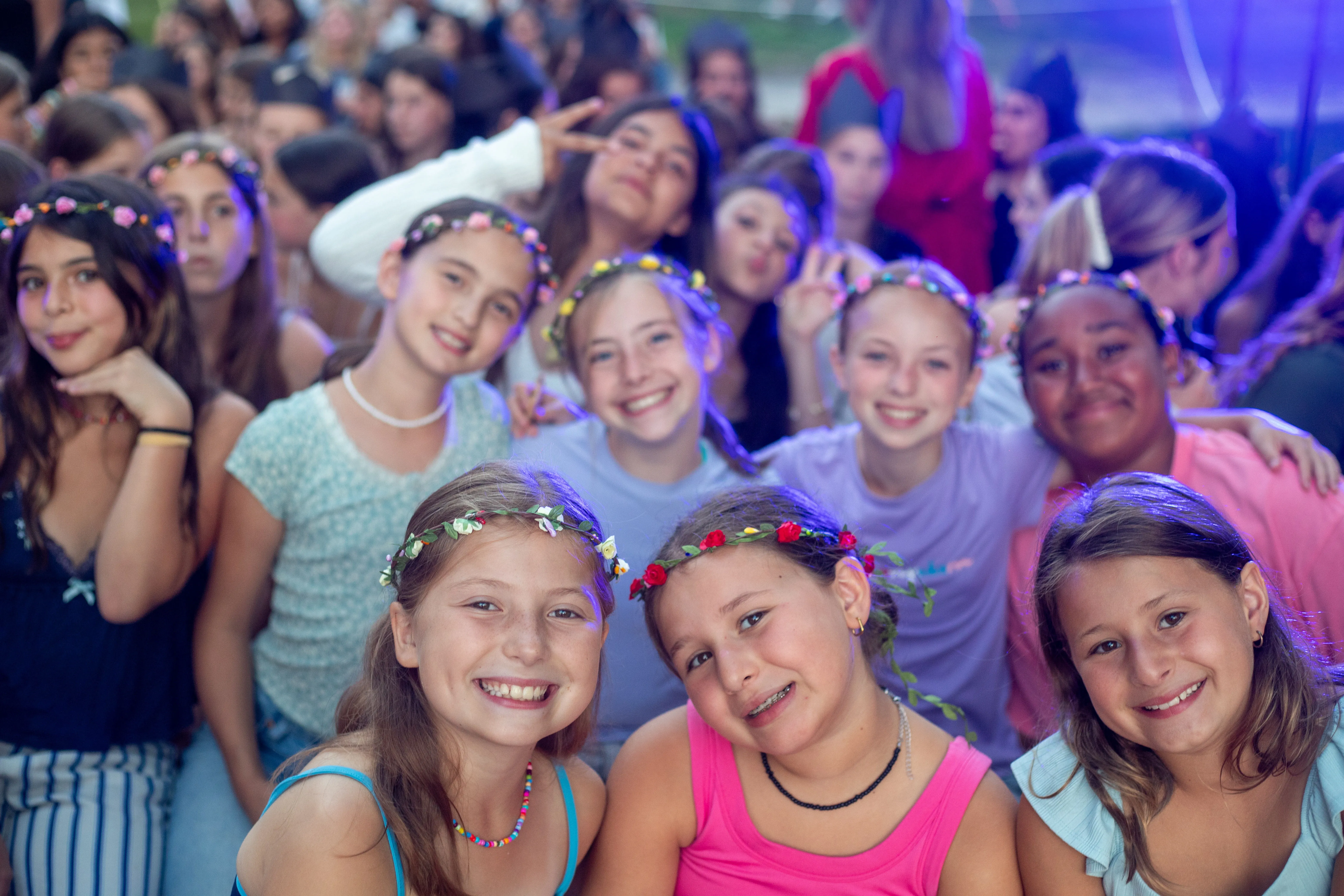 8 Group of campers posing together under colored lights
