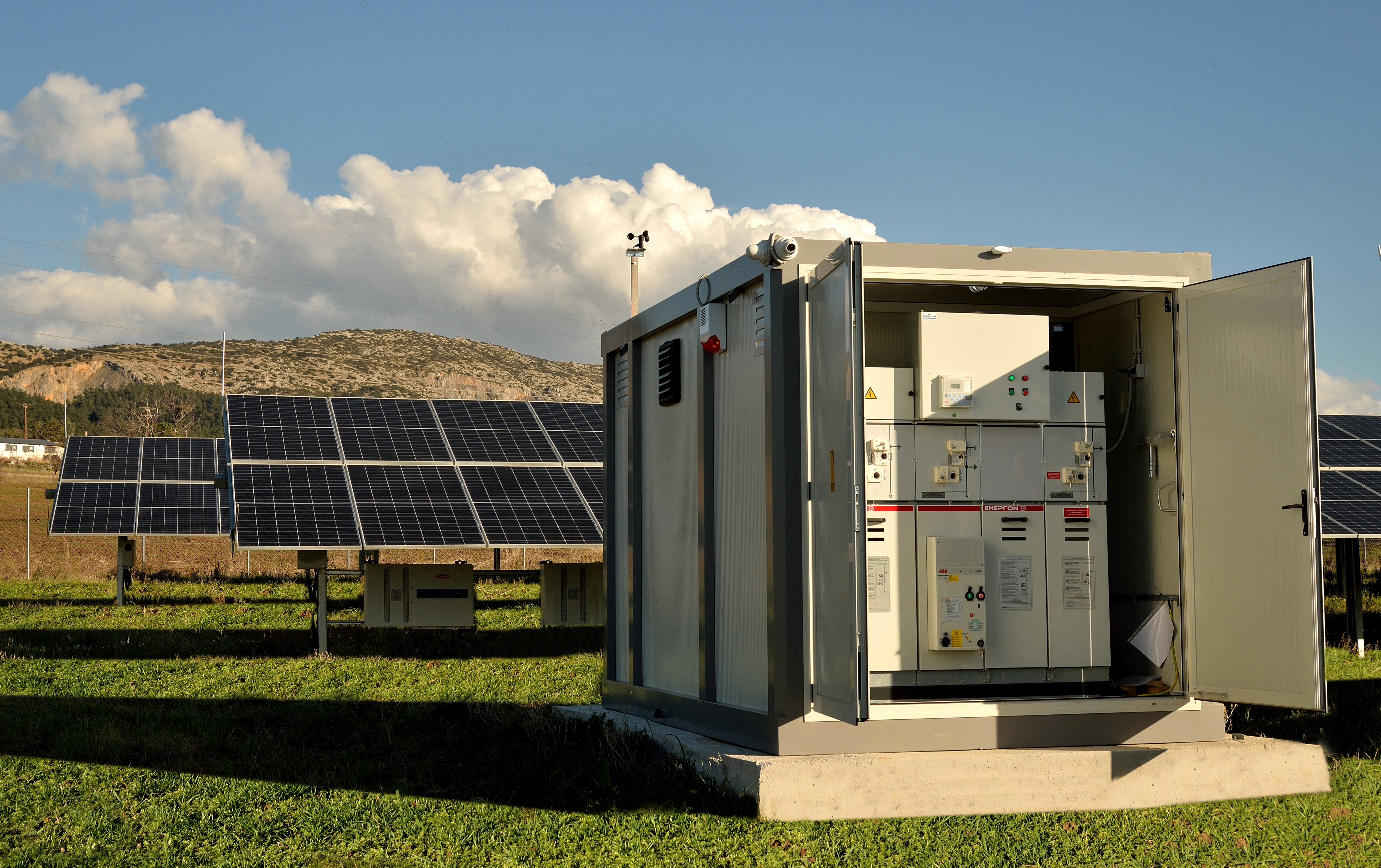 Central inverter station with open electrical cabinets serving utility-scale photovoltaic solar park