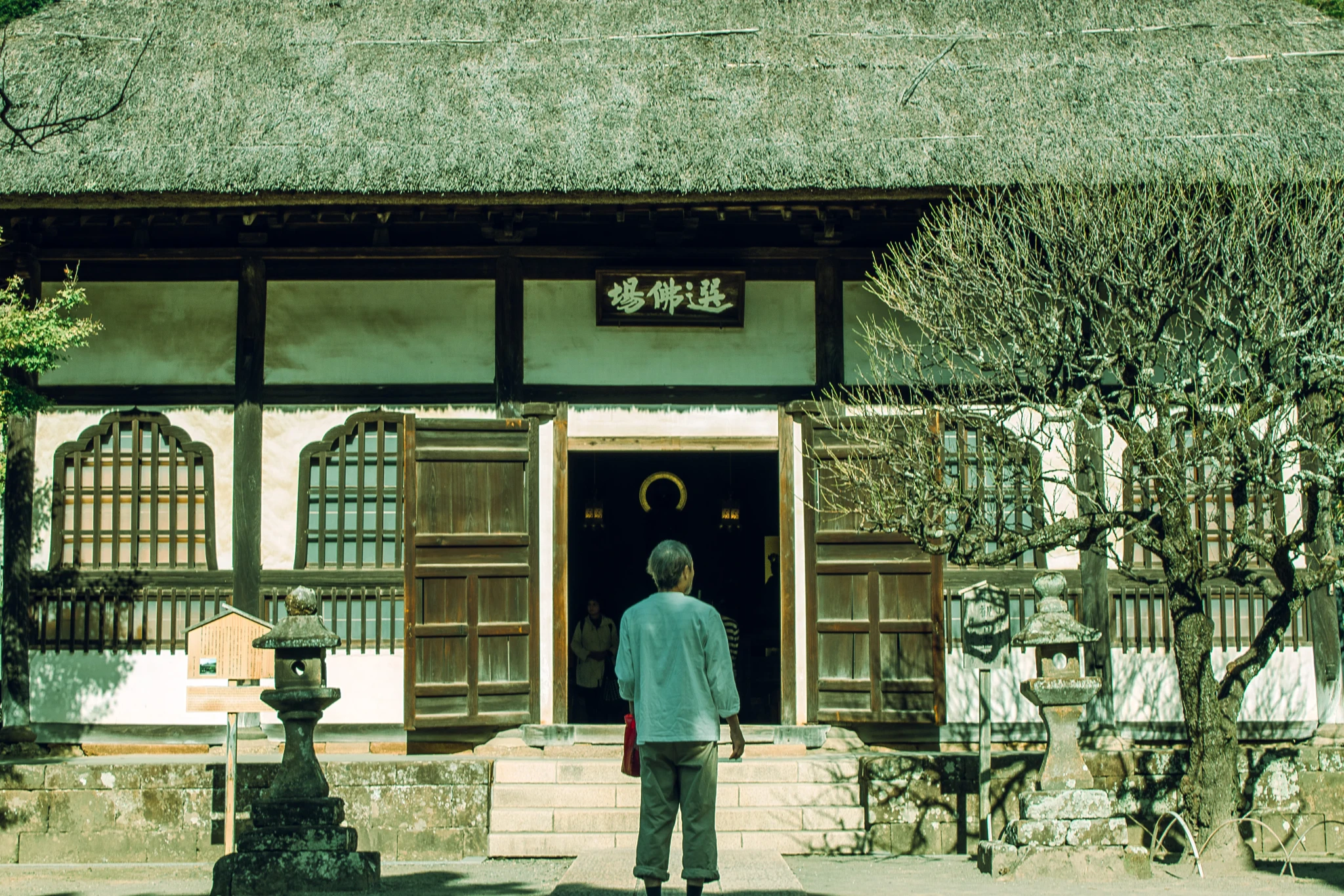 A man in the middle of a door of a japanese temple