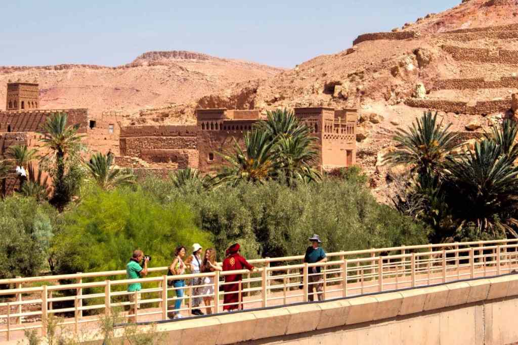 tourists crossing the bridge to ait ben haddou old village