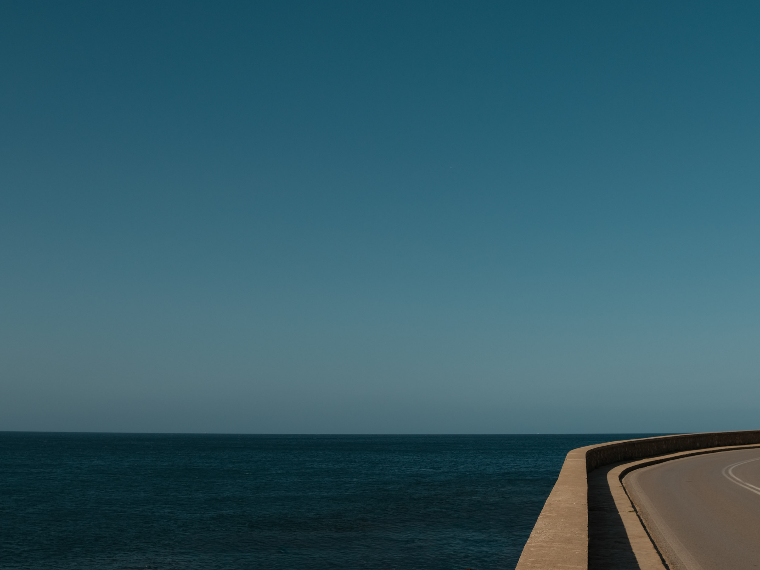 a road, the sea, and a clear horizon