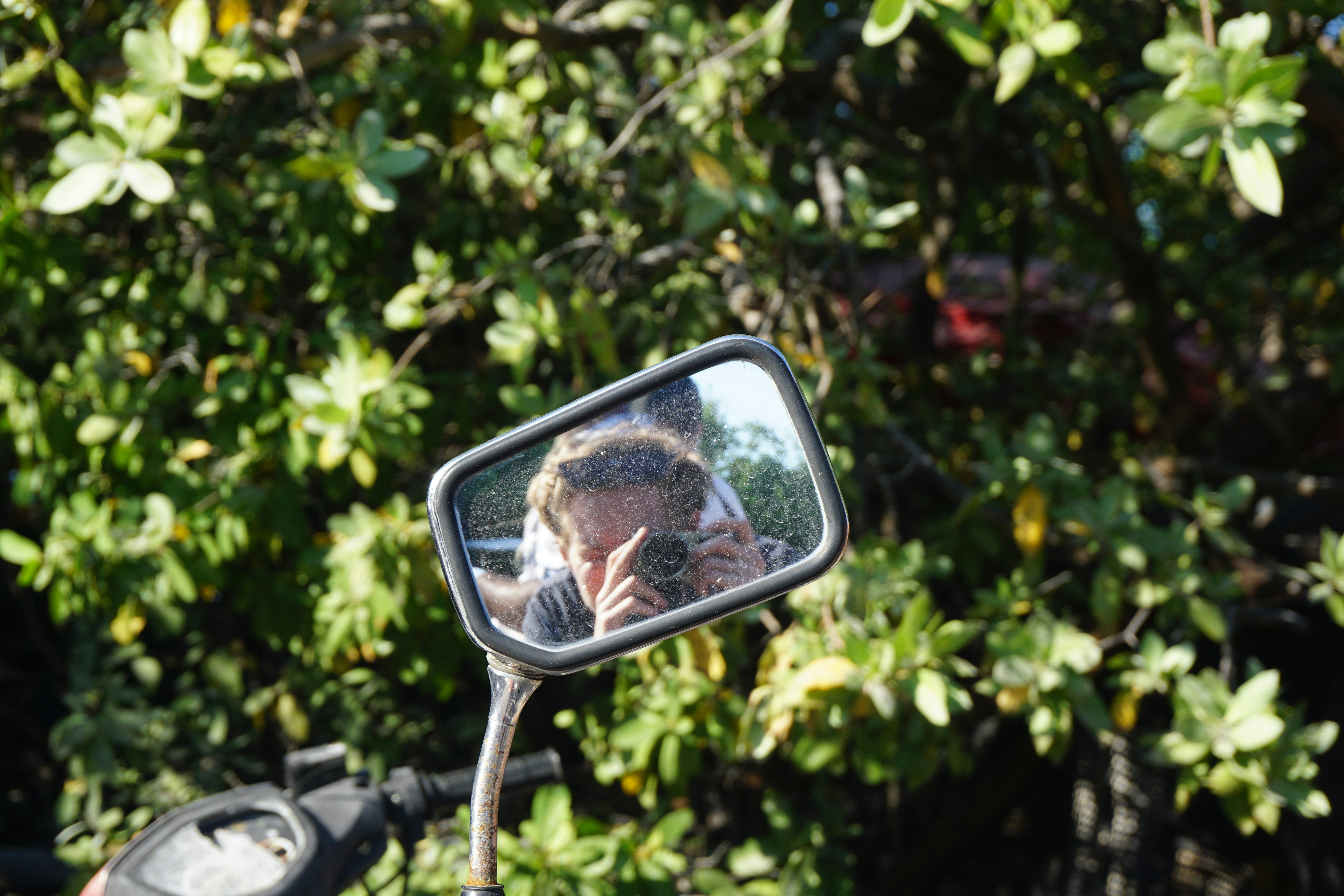 A woman talking on a cell phone while riding a motorcycle