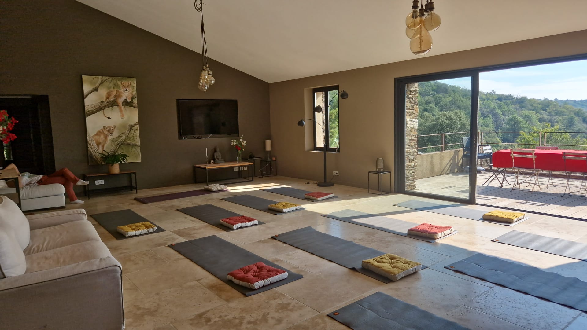Spacious yoga studio floor with mats and cushions set up for a teacher training workshop class.