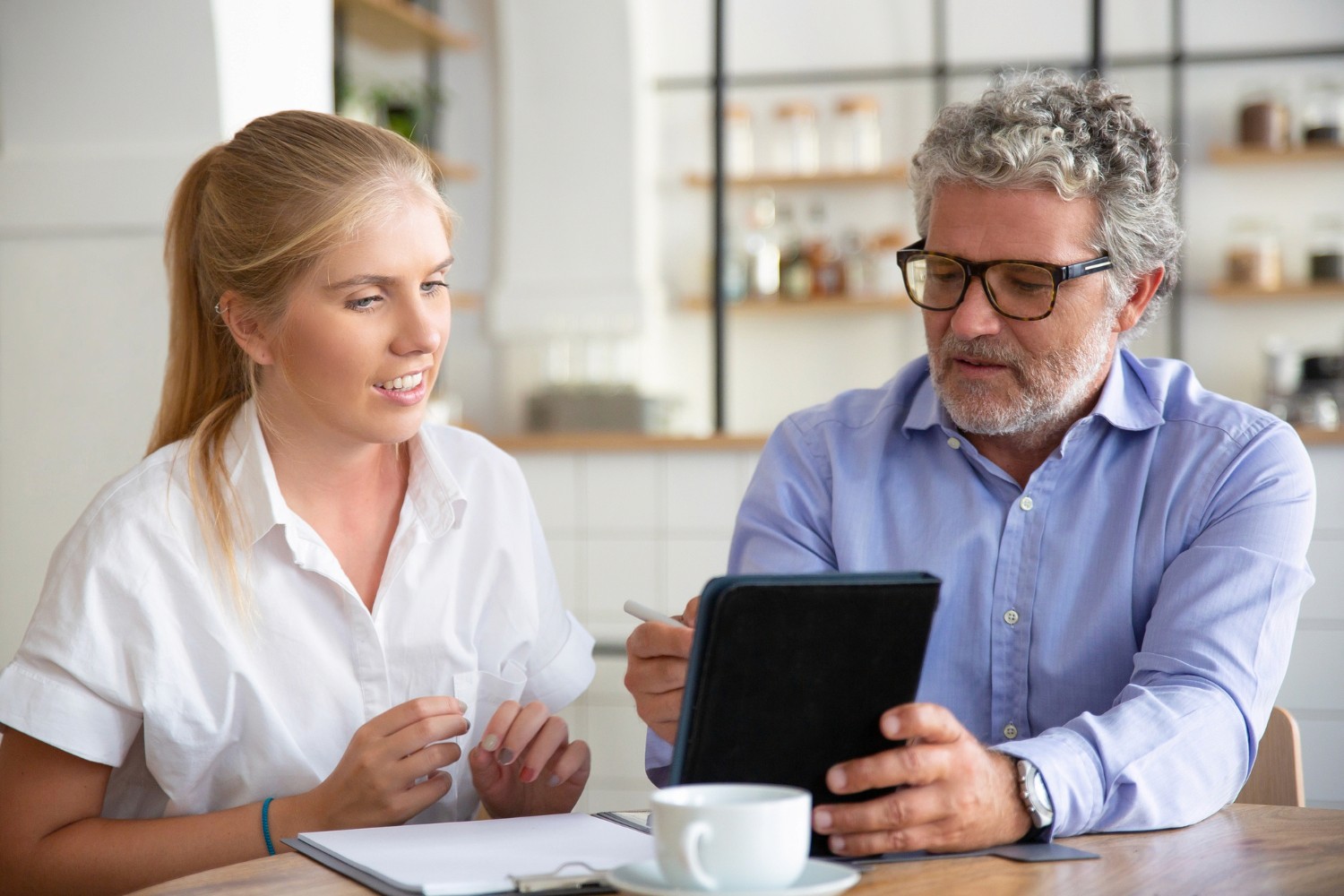 finance broker in brisbane holding ipad doing pre-approval with young woman smiling