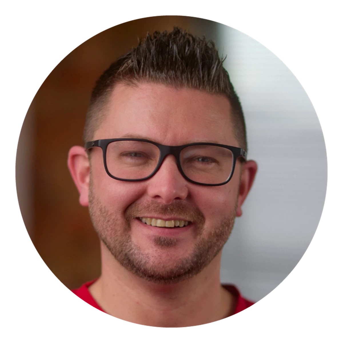 A circular portrait shows a person with short, spiked hair wearing a red top. The background transitions softly between warm and neutral tones.