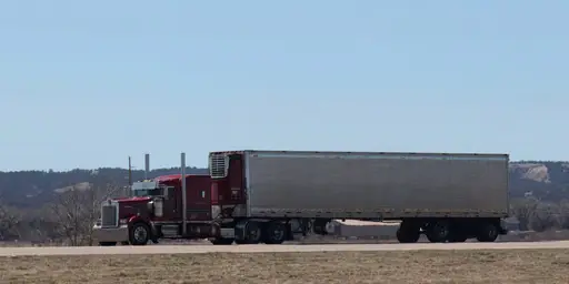 Un camión semirremolque grande conduciendo por una autopista